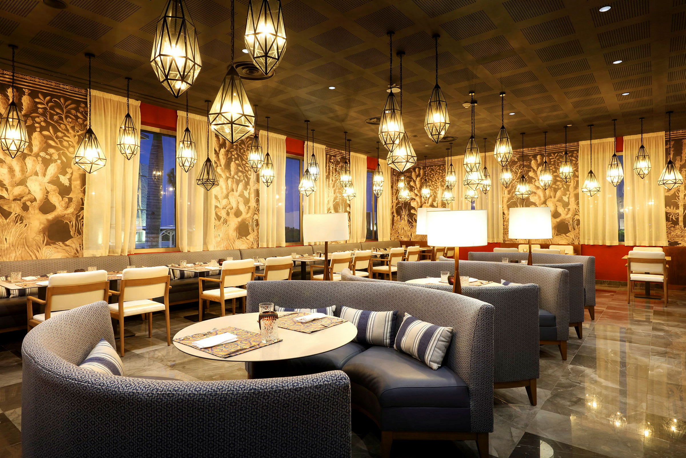 En pent innredet restaurant med hengende lamper, polerte gulv og fine møbler. (AI-generert tekst)