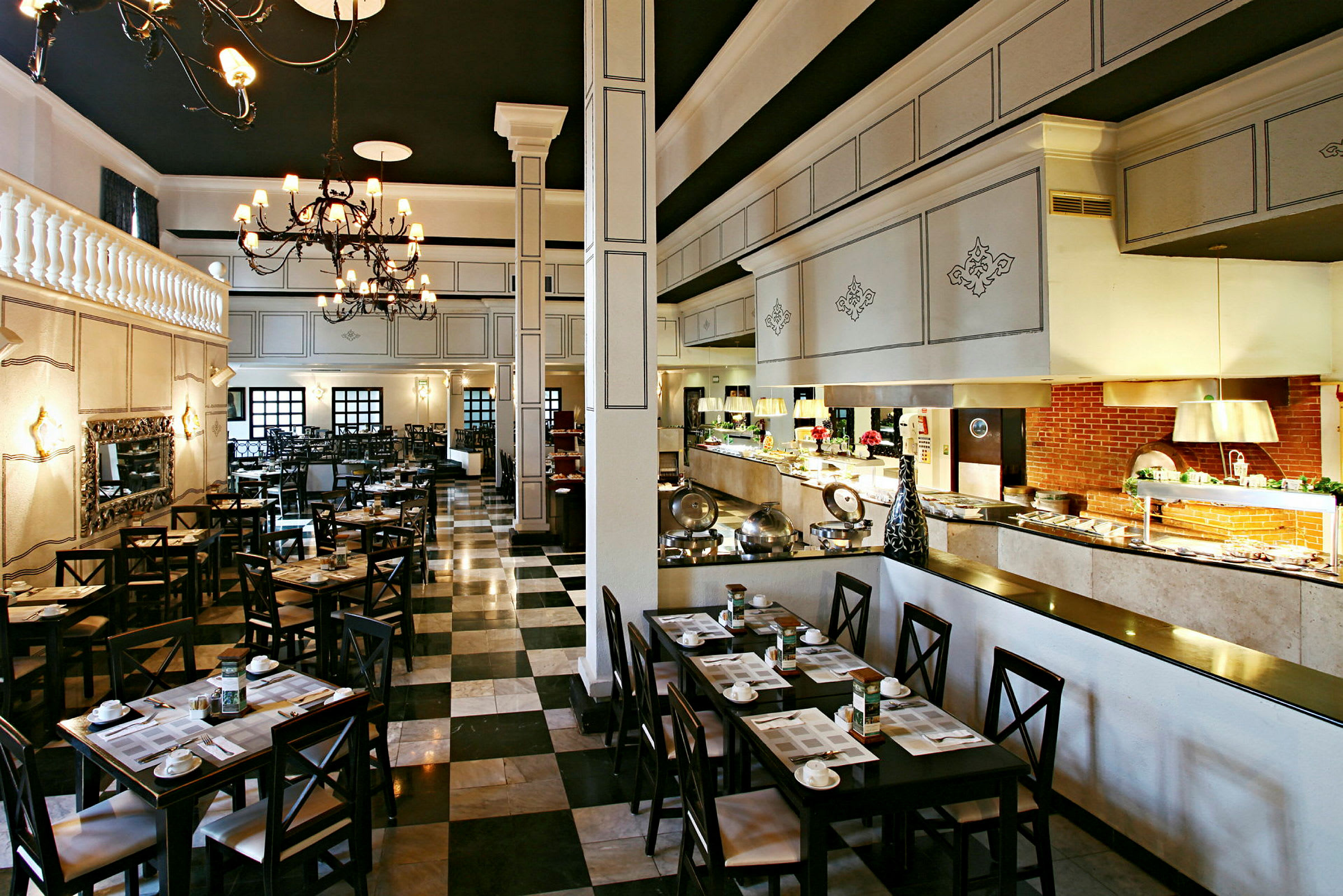 Bilde av en elegant restaurant med dekkede bord, store lysekroner og en buffet langs den ene siden. (AI-generert tekst)