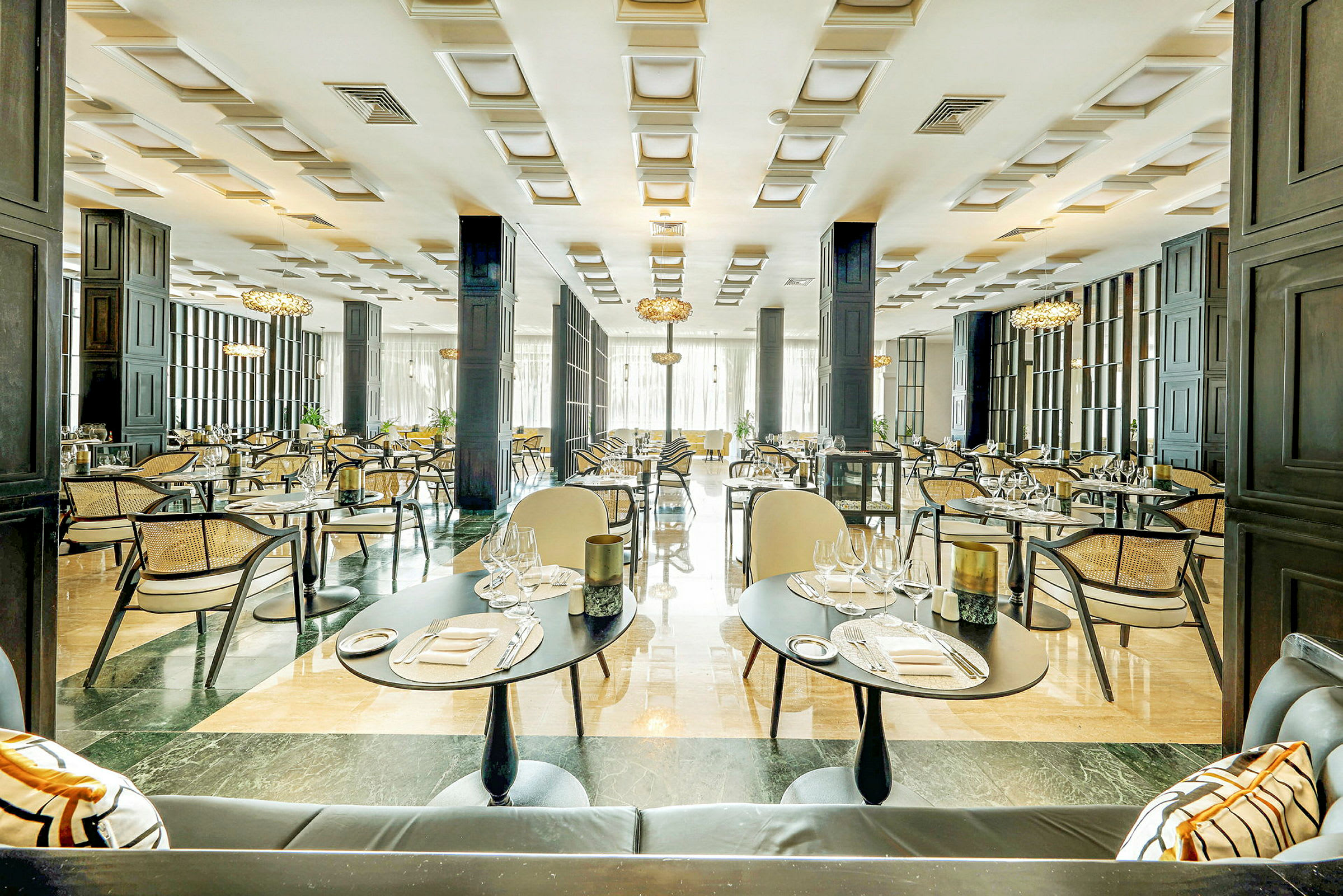En elegant restaurant med dekte bord, stoler og modern innredning. (AI-generert tekst)