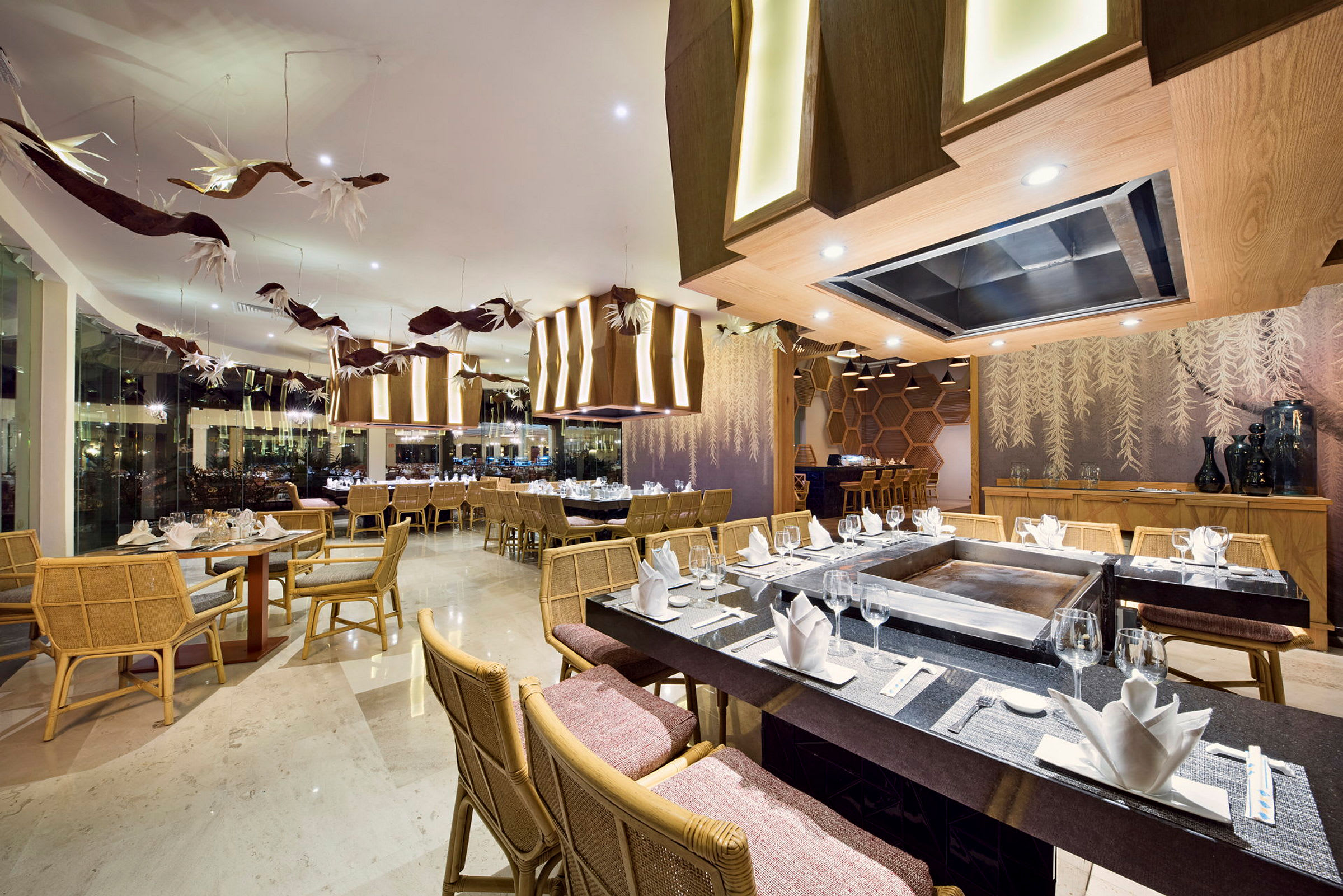 Bilde av en elegant restaurant med dekkede bord, moderne tredetaljer og dekorativ belysning. (AI-generert tekst)