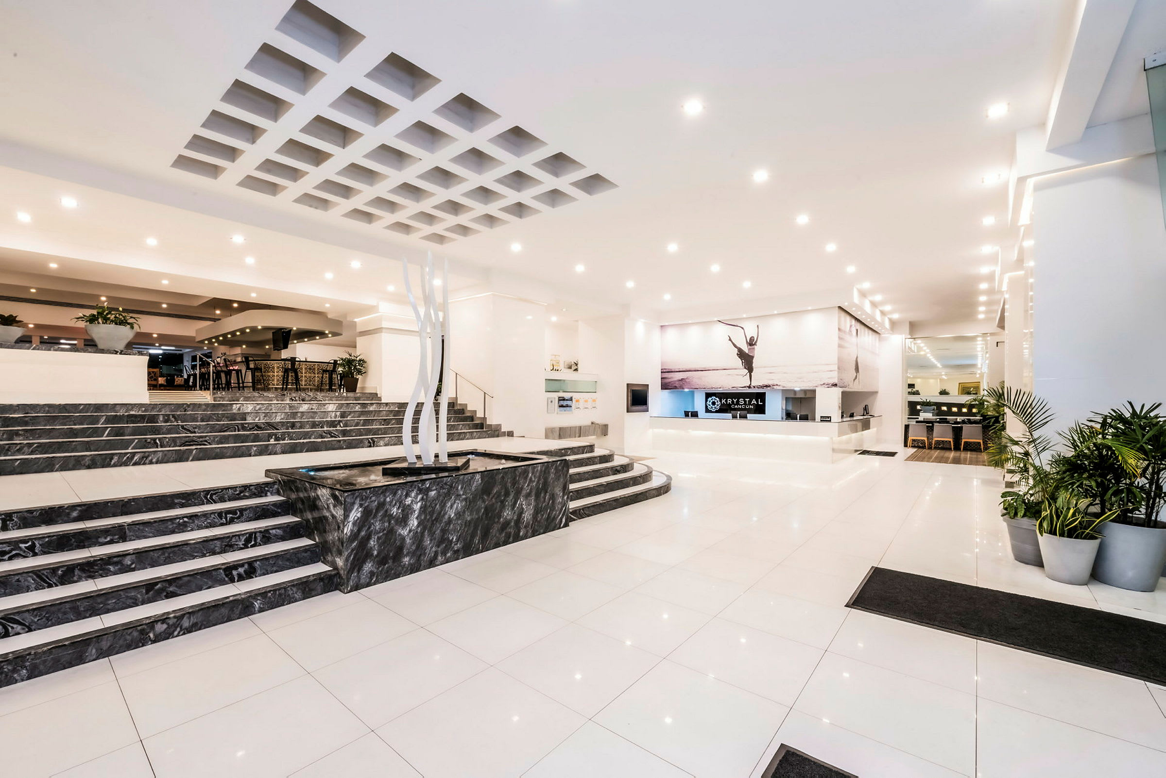 Hotellobby med resepsjon, marmorgulv og planter. (AI-generert tekst)