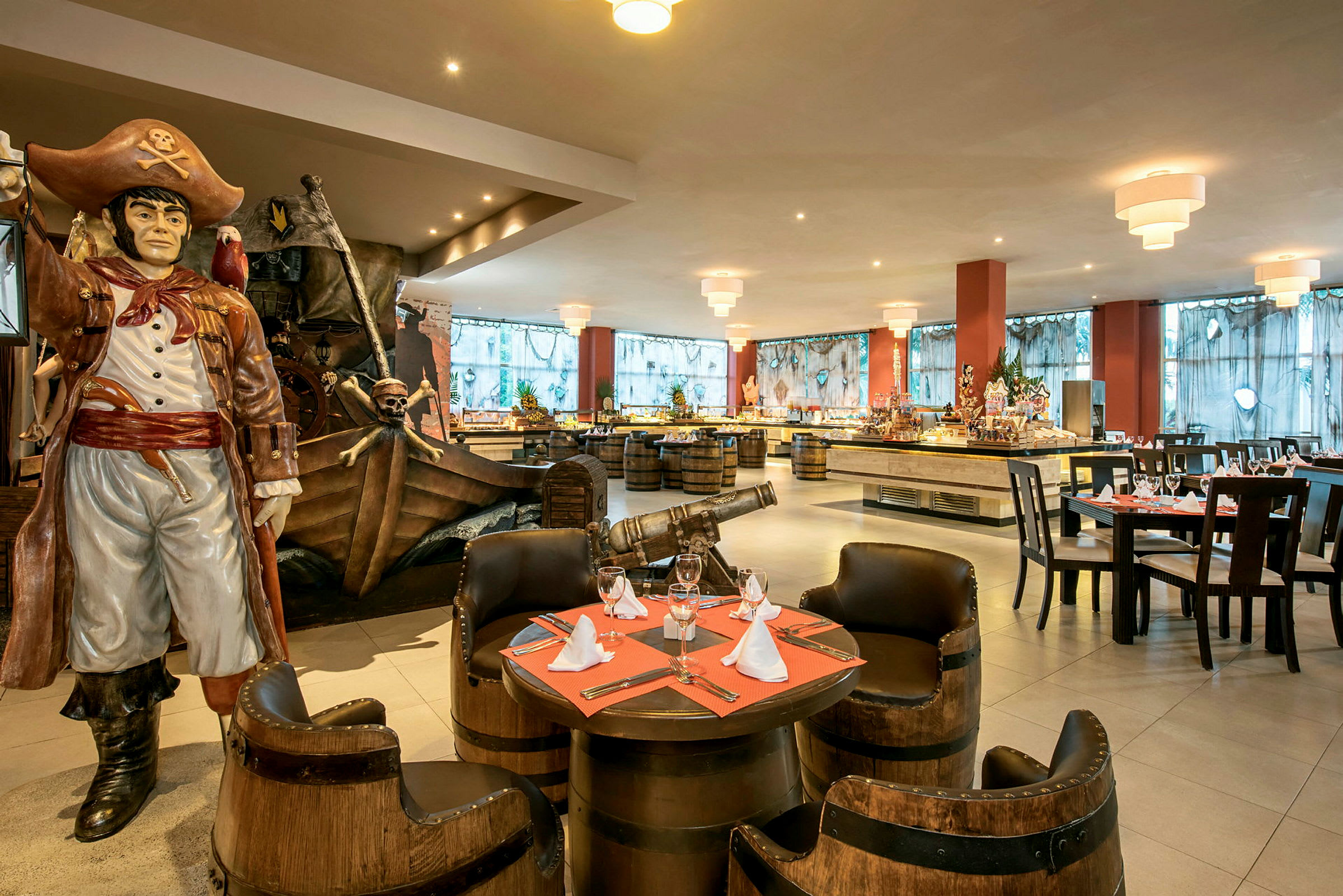 Bilde av en restaurant med sjørøvertema, hvor det finnes en stor statue av en sjørøver ved siden av dekorasjoner som en kanon og et skip. Restauranten er innredet med bord og stoler. (AI-generert tekst)