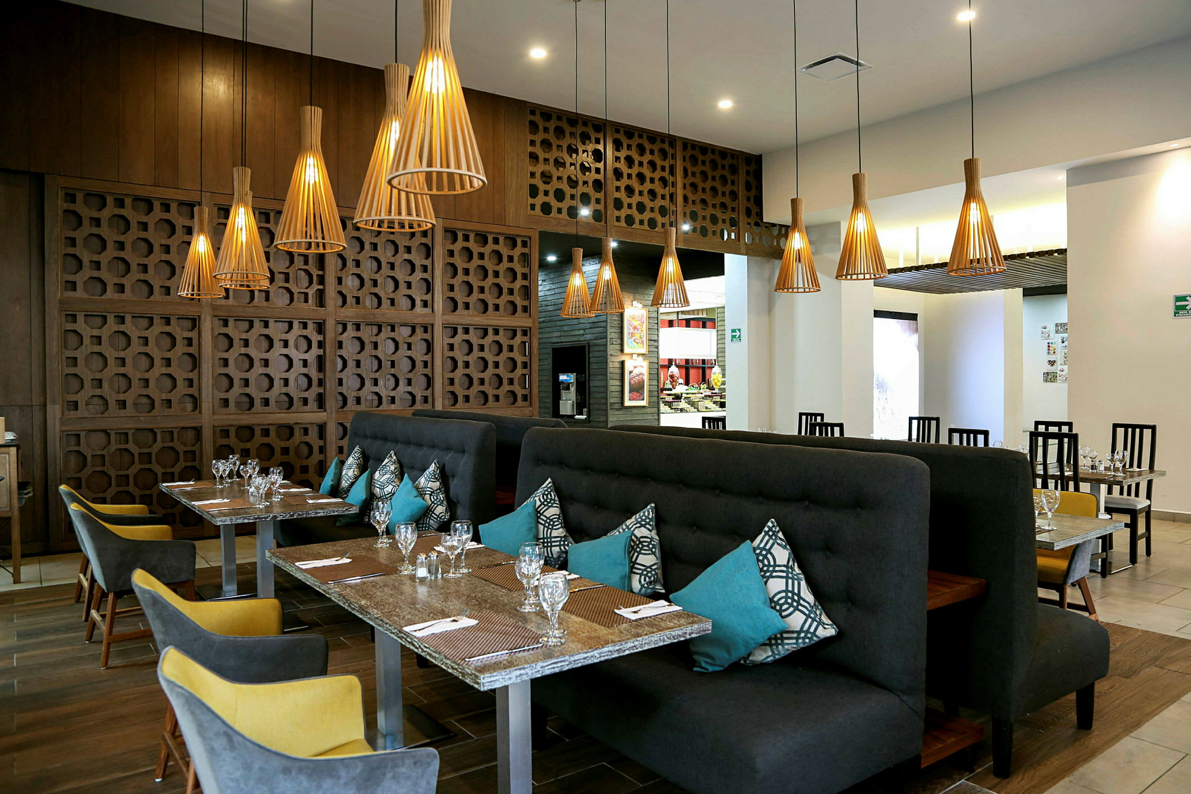 En restaurant med elegante bord og stoler, stilfull belysning og moderne dekorative elementer. (AI-generert tekst)