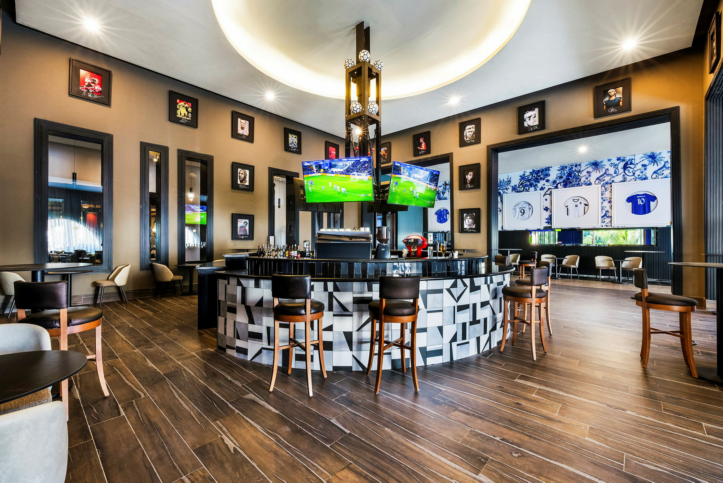 En elegant bar med sporttemainnredning og fire TV-skjermer som viser kamper. (AI-generert tekst)