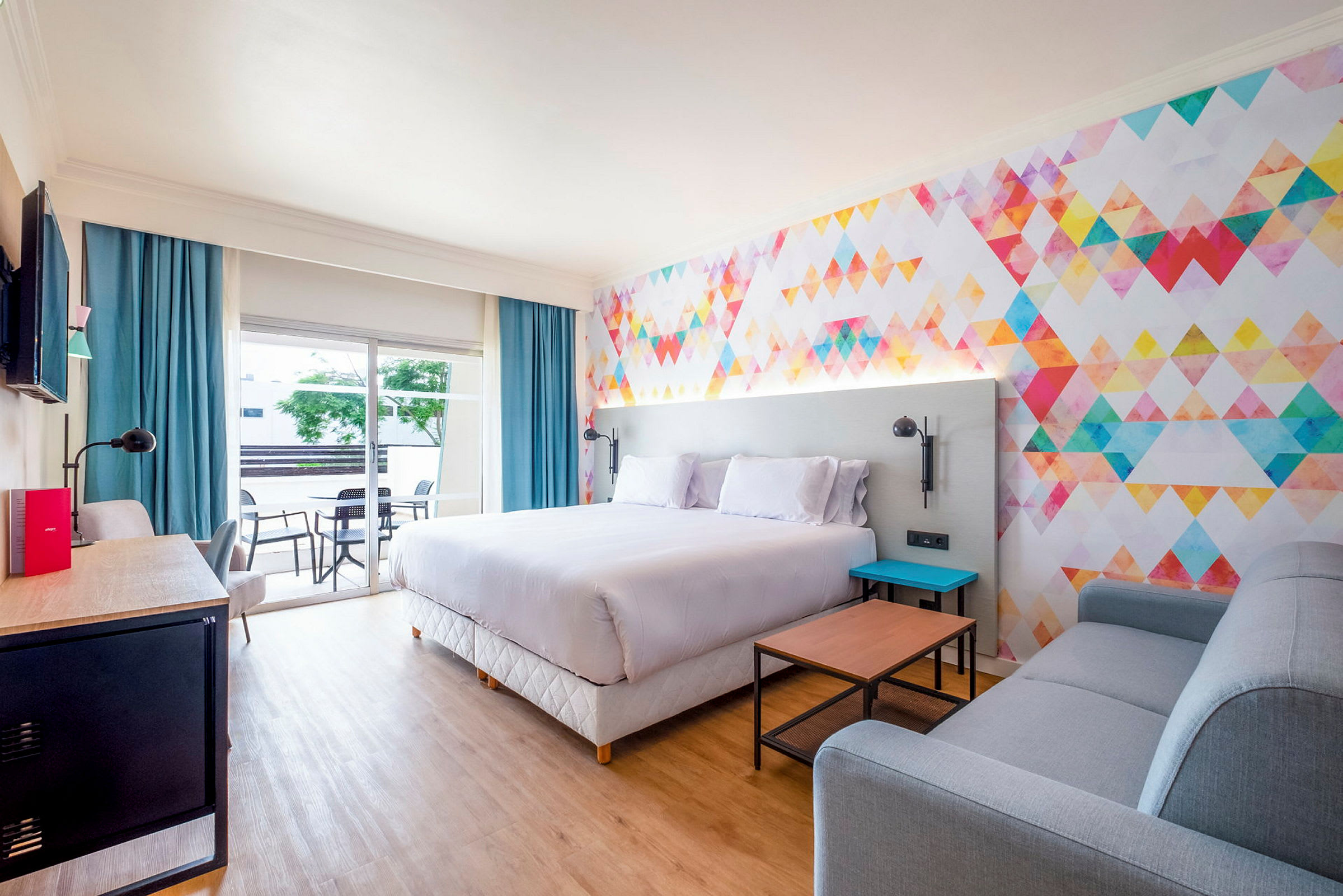Moderne hotellrom med fargerikt veggdesign og komfortable møbler. (AI-generert tekst)
