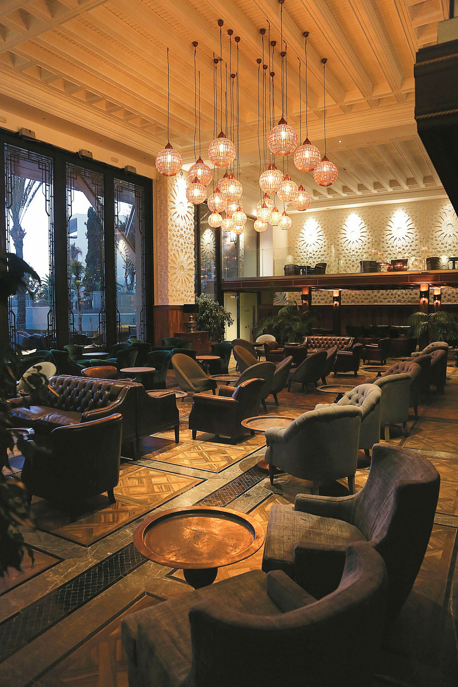 Interiør av en elegant lounge med komfortable sittemøbler og belysning fra taklamper. (AI-generert tekst)