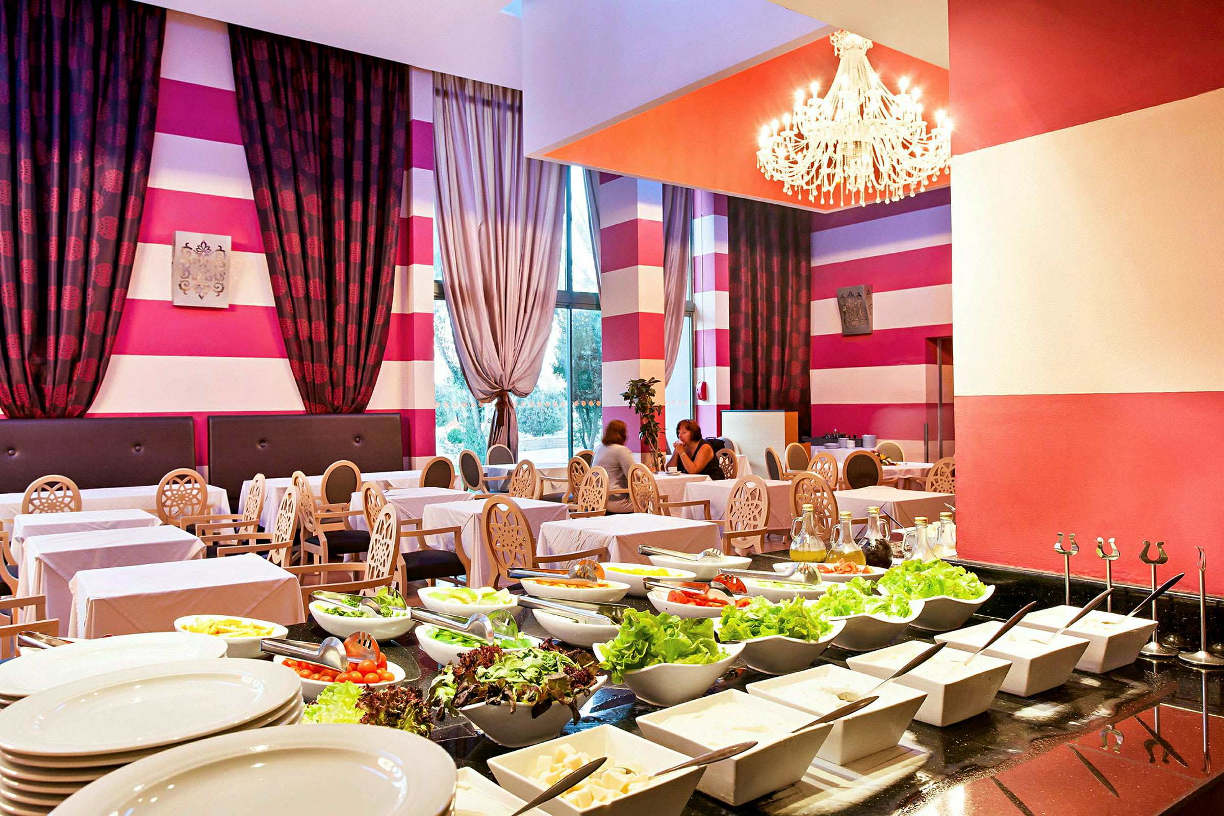 Restaurantmiljø med dekkede bord for gjester og en buffet med salat i forgrunnen. (AI-generert tekst)