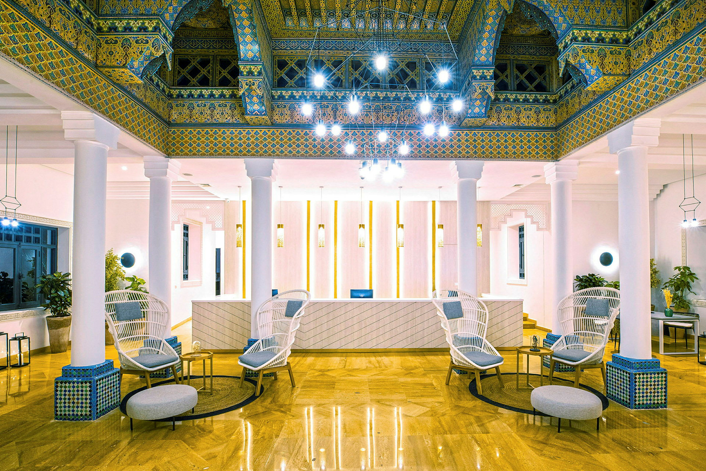 Lobbyen på et hotell med elegant innredning, inkludert stoler, bord og dekorative takdetaljer. (AI-generert tekst)