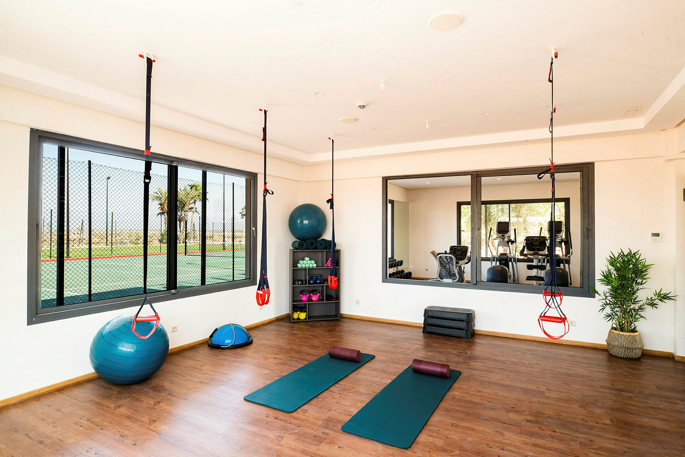 Gym med treningsmatter, styrketreningsutstyr og opphengstreningssystem. (AI-generert tekst)