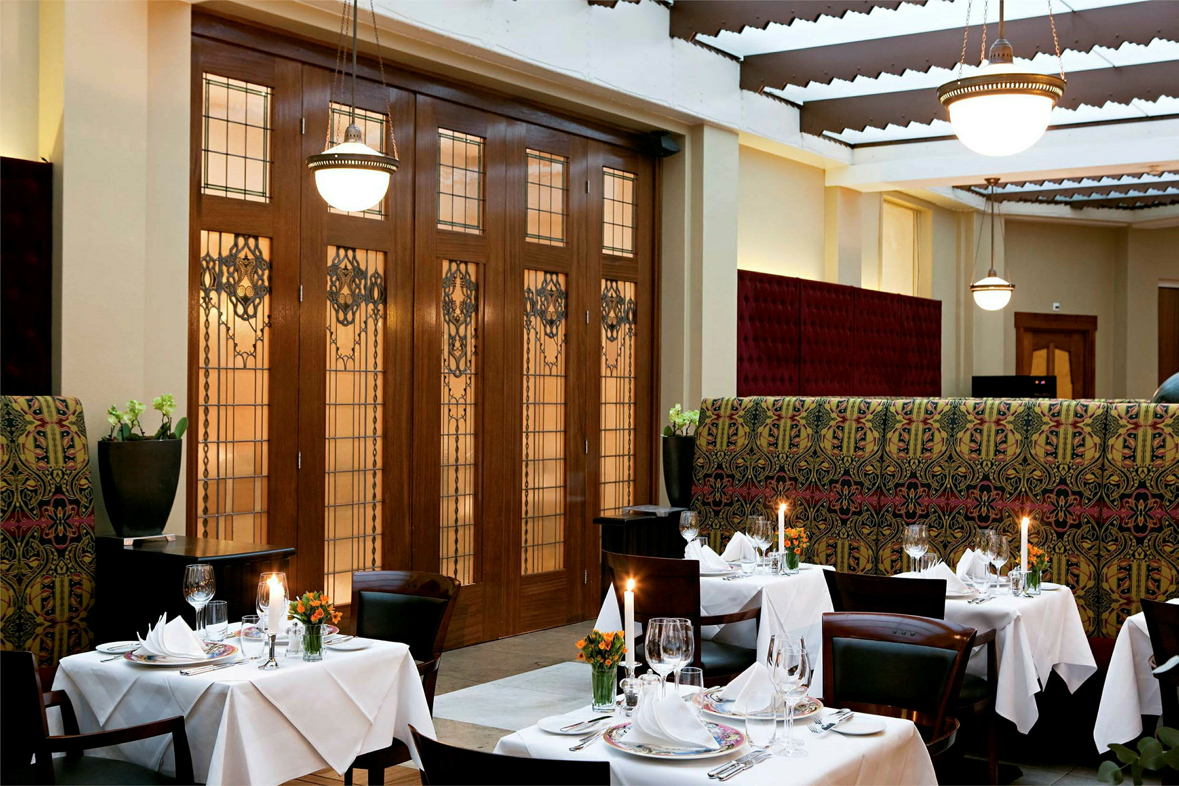 En elegant restaurant med oppdekkede bord, lysestaker og dekorativ innredning. (AI-generert tekst)