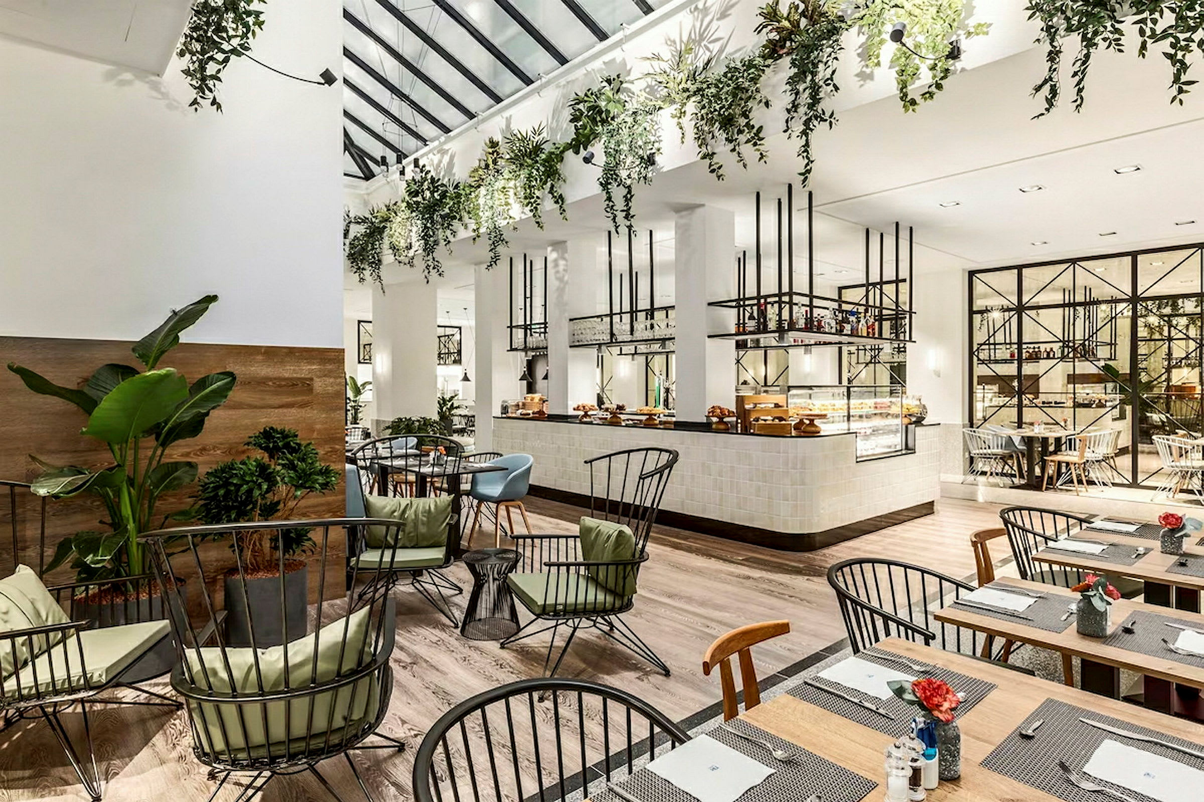 Interiør av en lys og moderne restaurant med planter og elegant møblering. (AI-generert tekst)