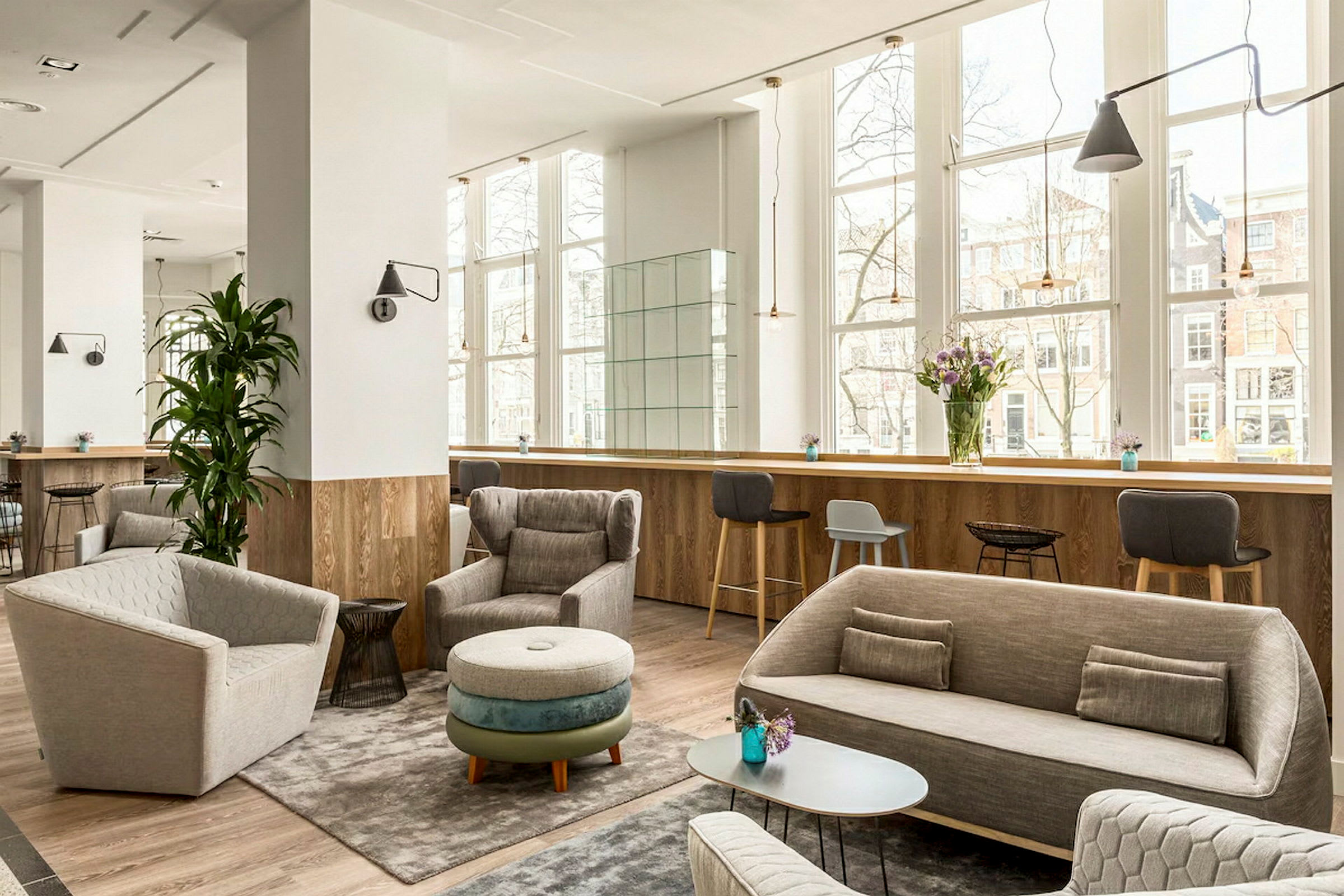 Lyst og moderne lounge med møbler foran store vinduer. (AI-generert tekst)