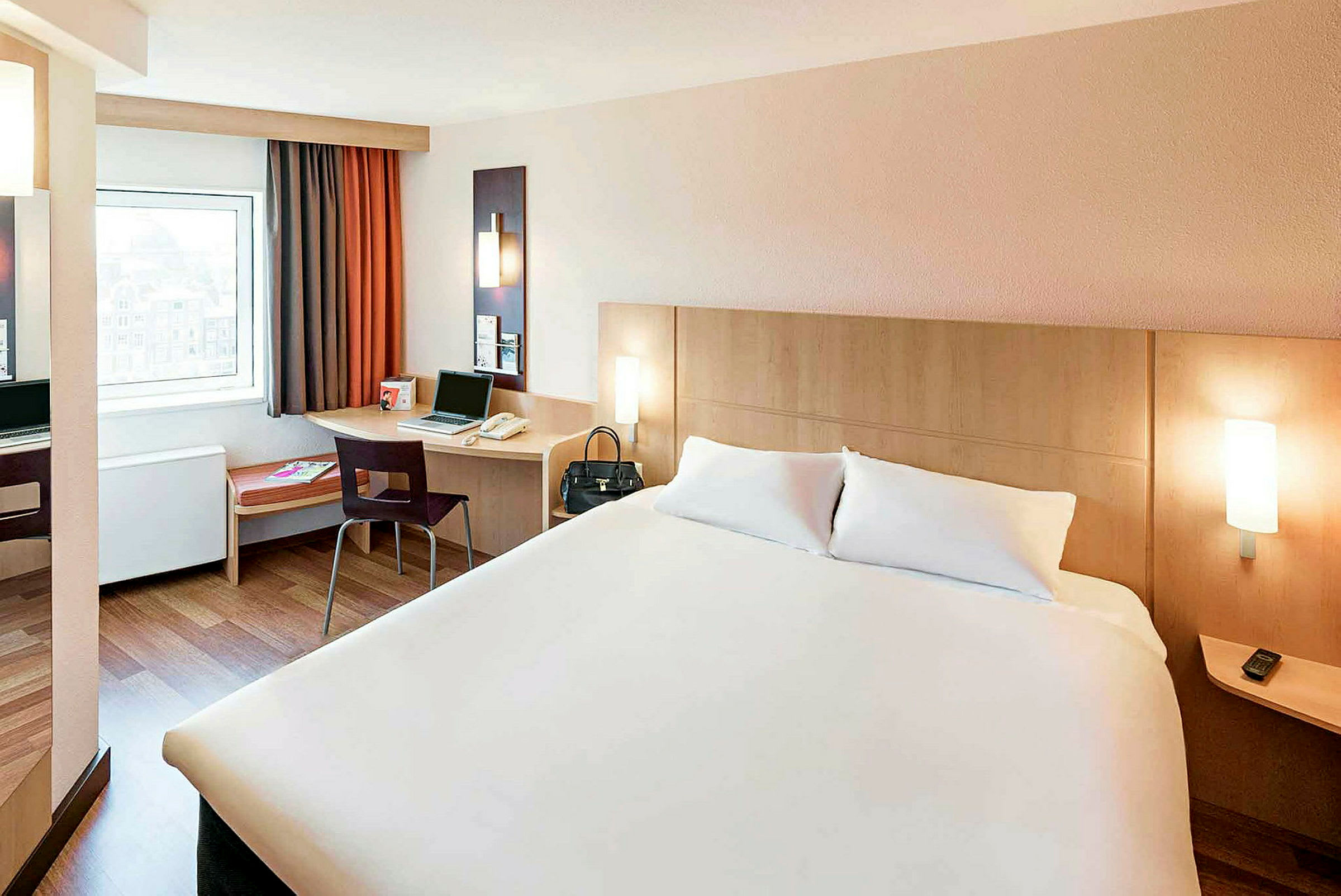 Hotellrom med en dobbeltseng, et skrivebord med en stol og et vindu. (AI-generert tekst)