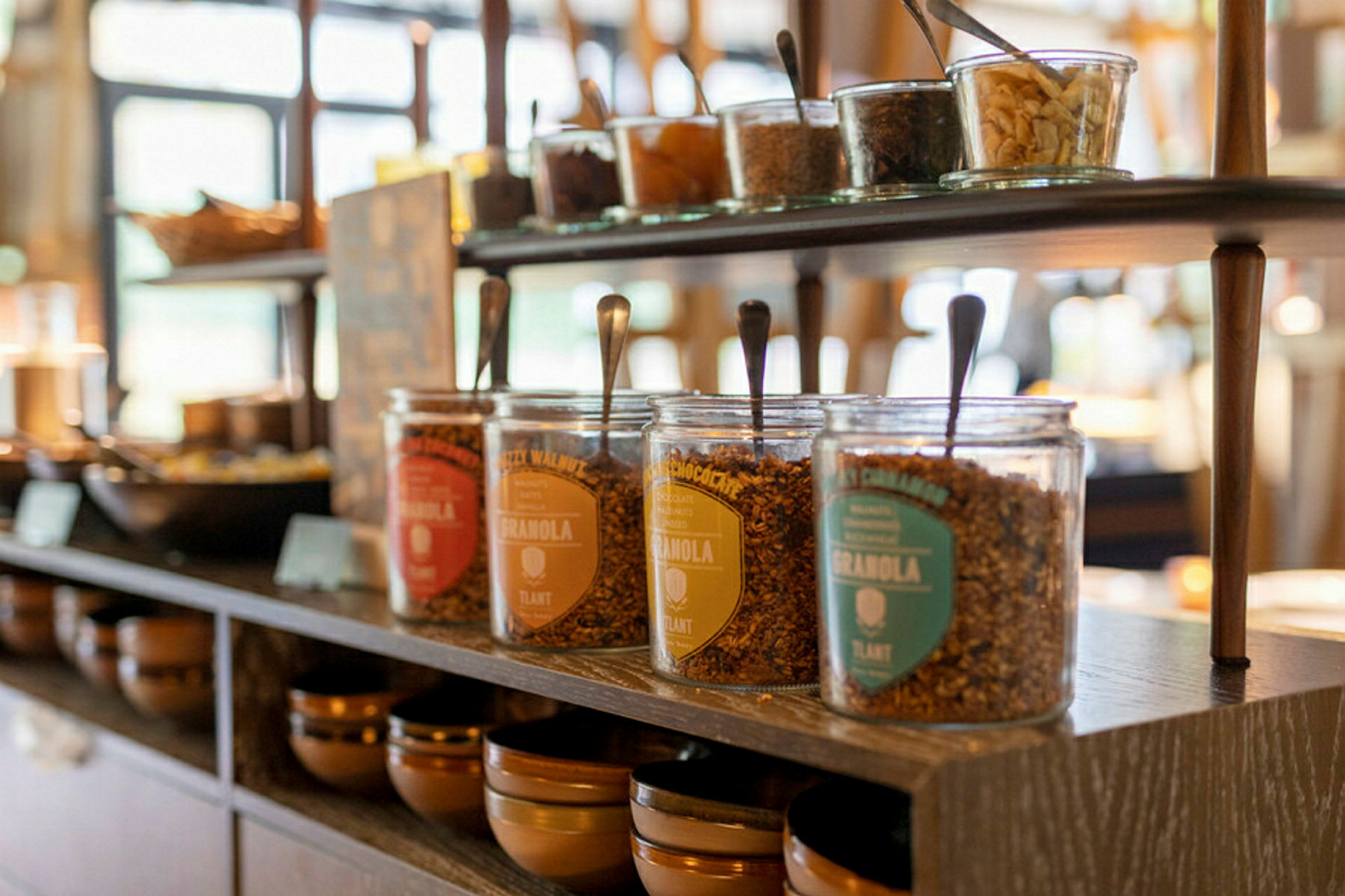Flere glasskrukker med granola på en hylle i nærbilde. (AI-generert tekst)
