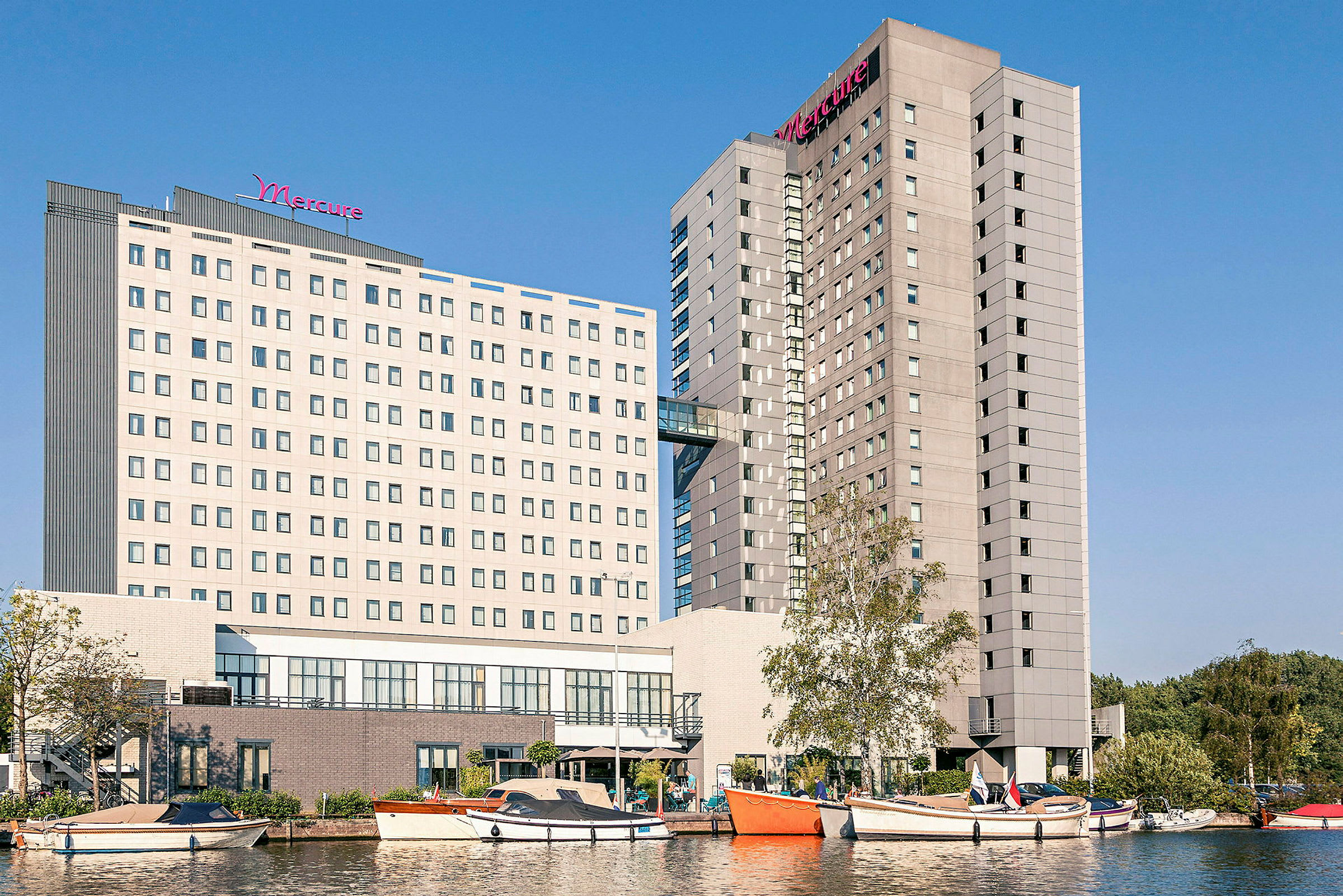 Bilde av hotellbygninger med båter og vann i forgrunnen. (AI-generert tekst)