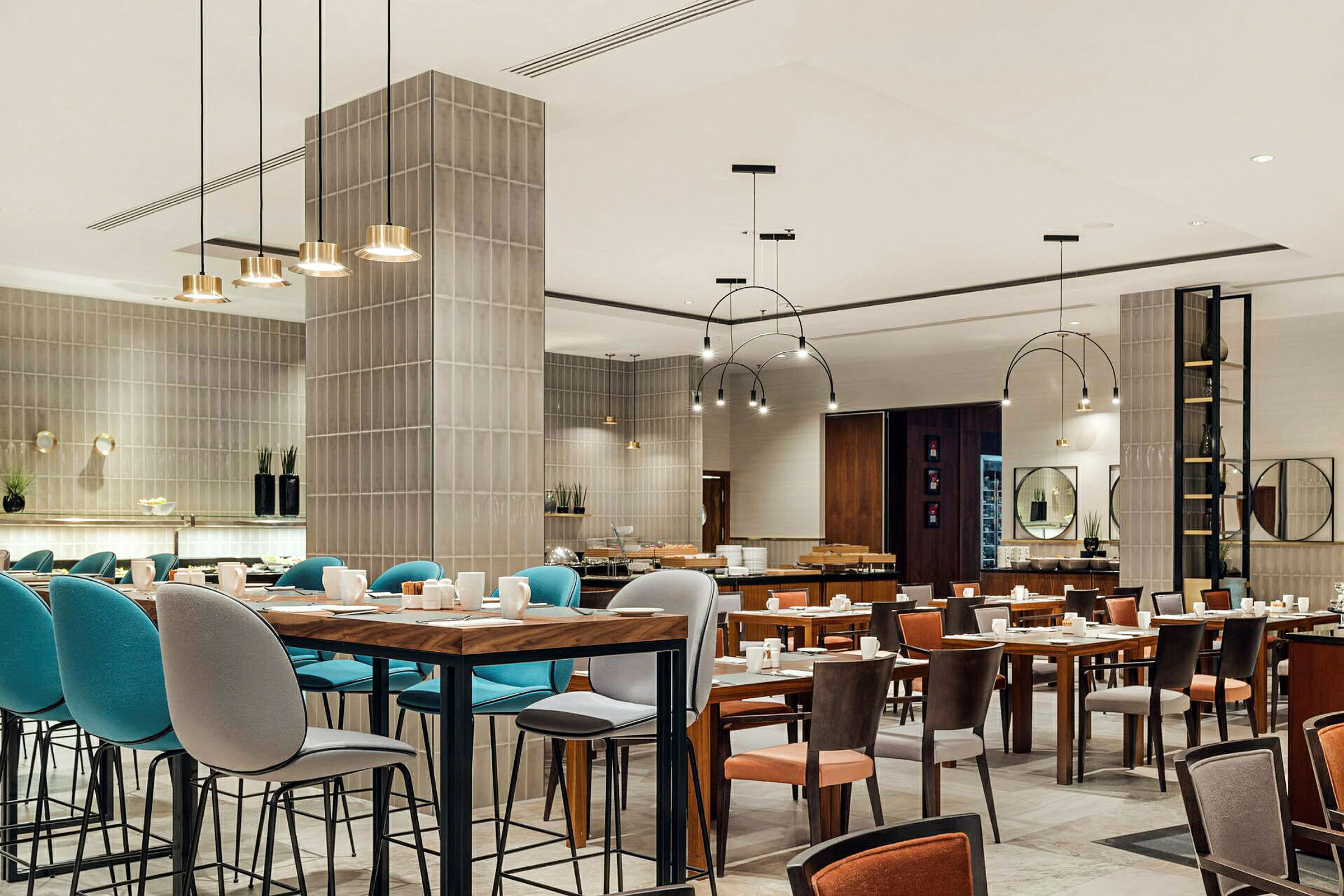 Restaurantinteriør med bord og stoler, moderne innredning og hengende taklamper. (AI-generert tekst)
