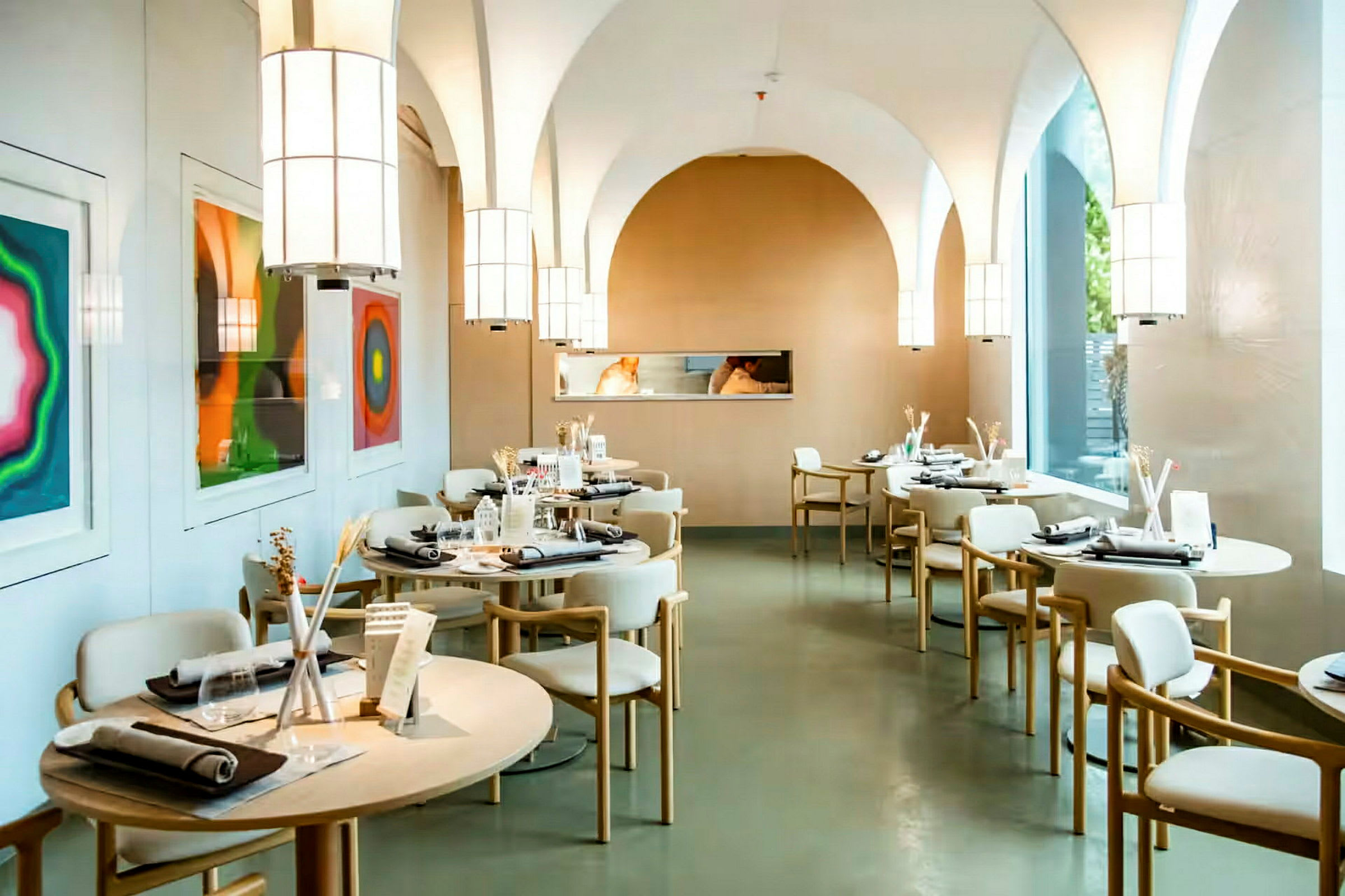 En moderne restaurant med oppdekkede bord og kunstverk på veggen. (AI-generert tekst)