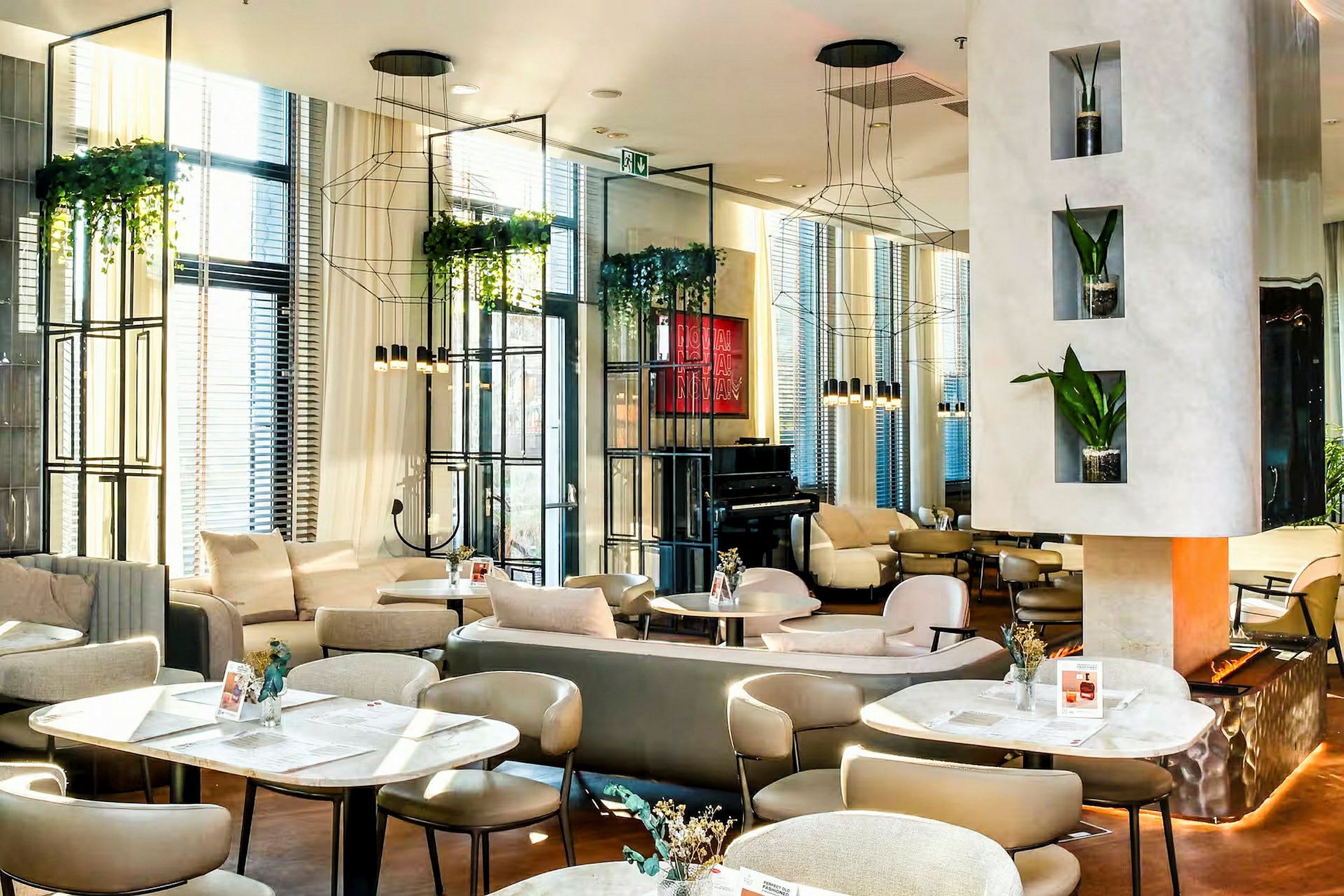 En moderne lounge med elegante møbler, hengende planter og et piano i bakgrunnen. (AI-generert tekst)