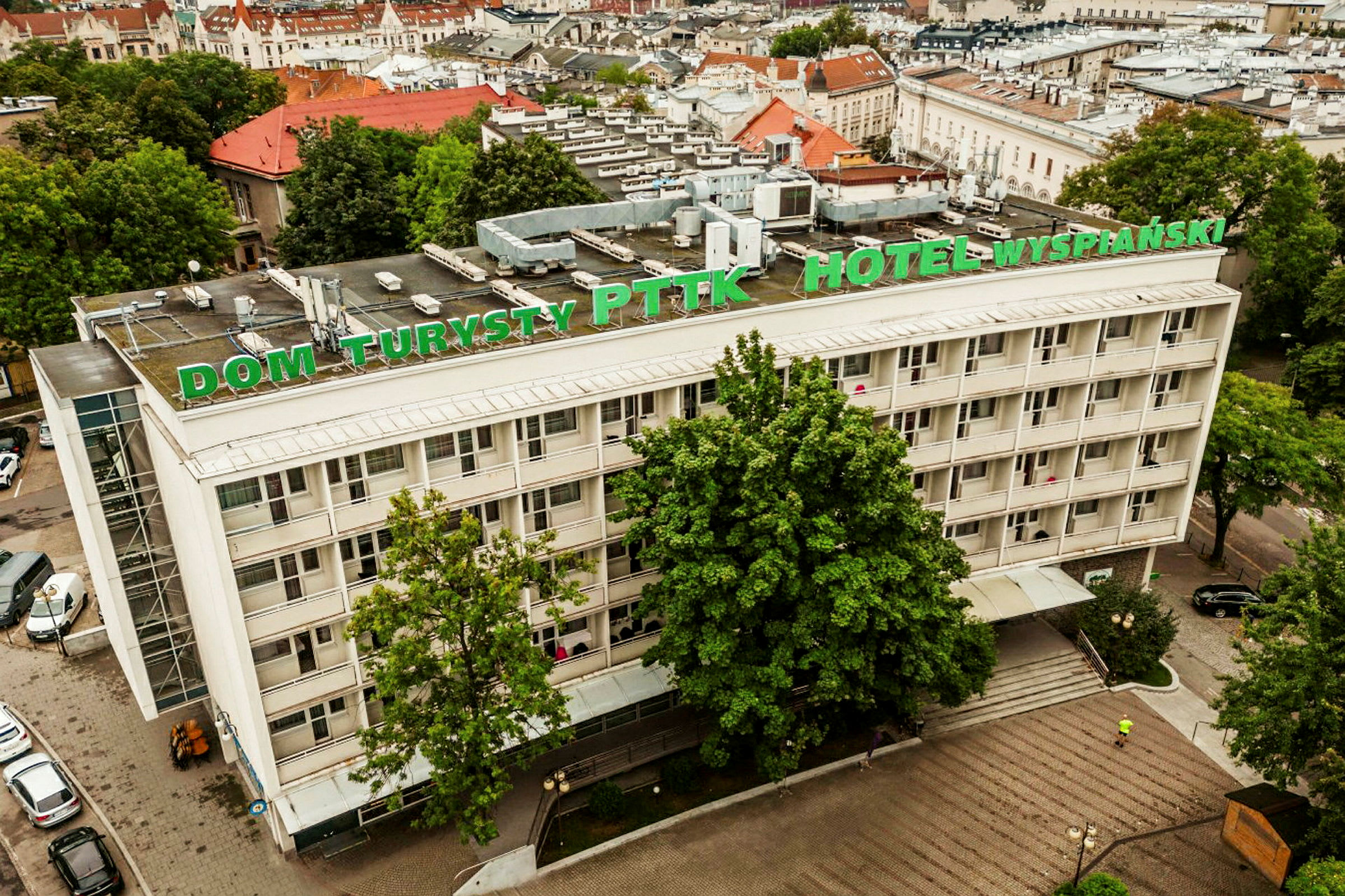 Utsikt ovenfra av et hotell med skiltet "Dom Turysty PTTK Hotel Wyspiański". (AI-generert tekst)