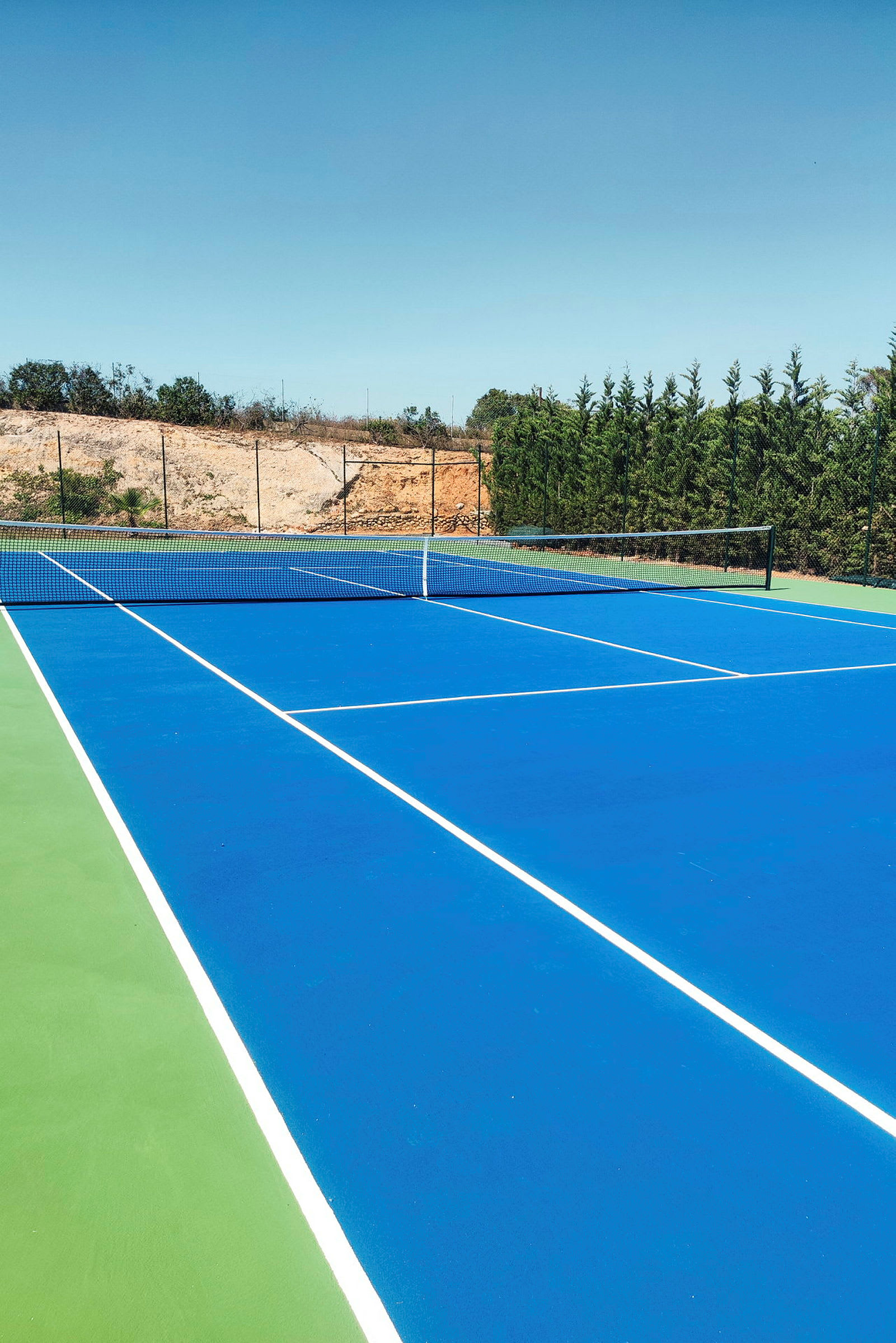 Bilde av en tennisbane med blått underlag. (AI-generert tekst)