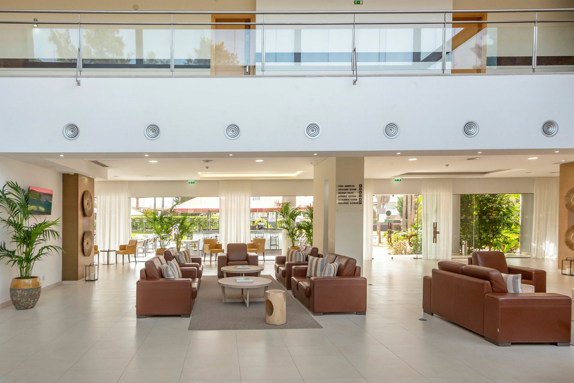 Hotellobby med sittegrupper og store vinduer. (AI-generert tekst)