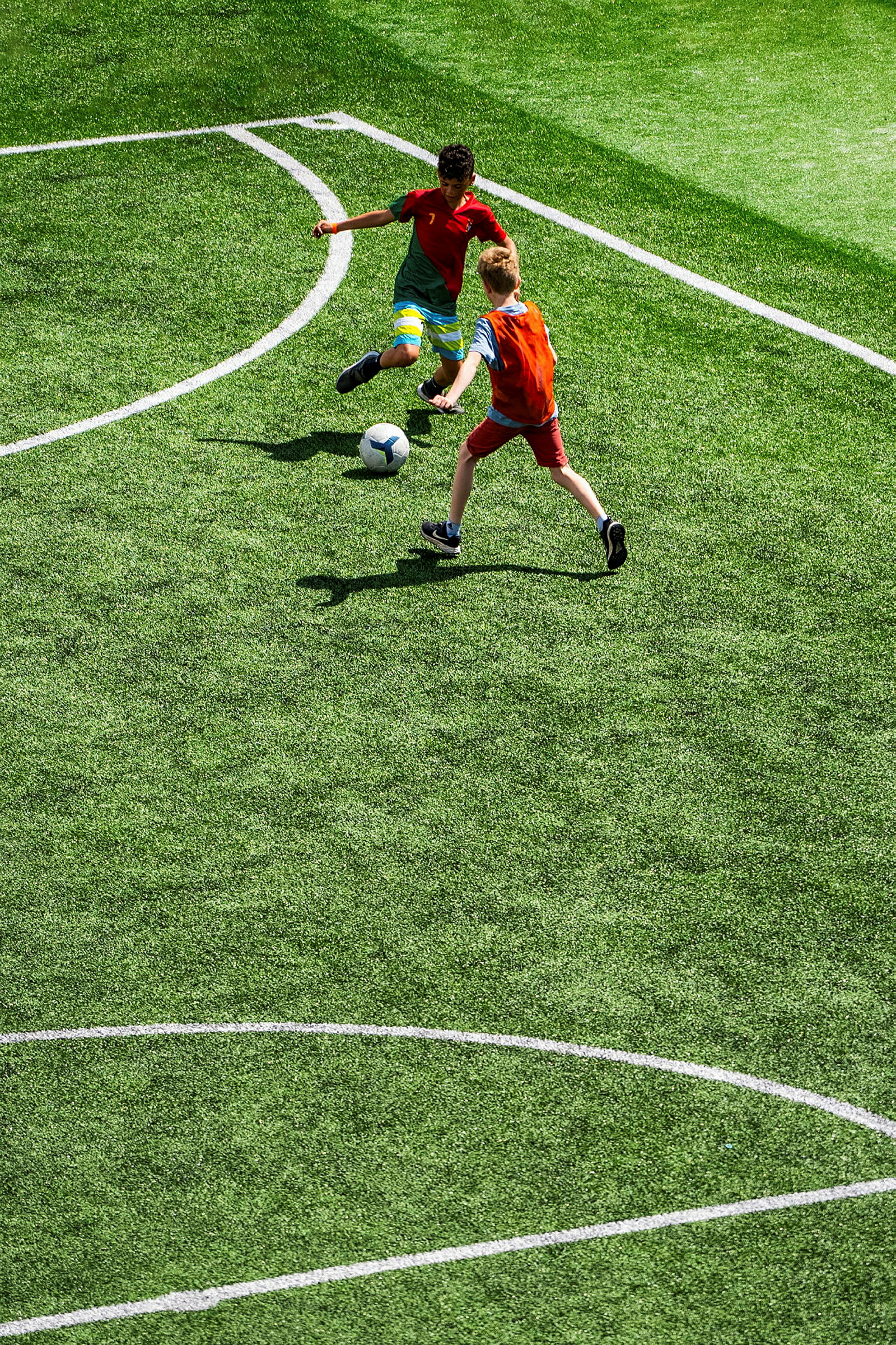 To personer spiller fotball på en gressbane. (AI-generert tekst)