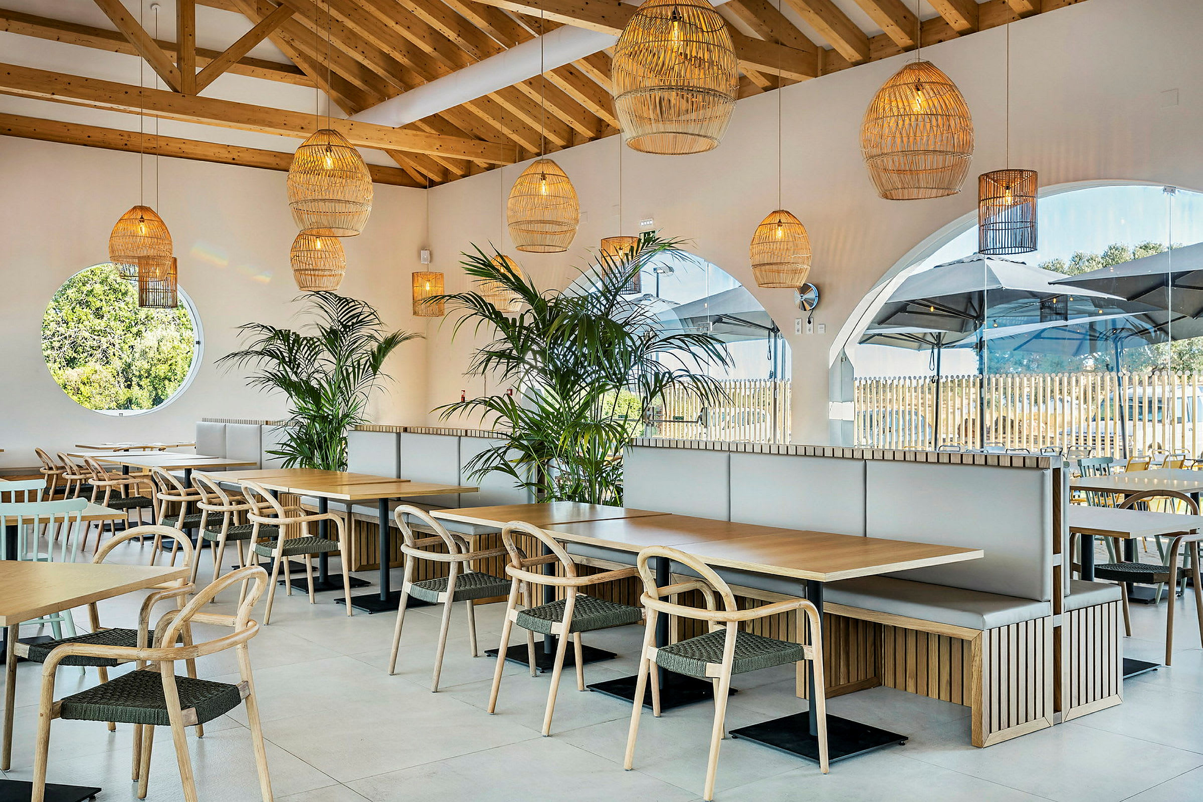 En moderne restaurant med trebord, stoler og grønne planter. (AI-generert tekst)