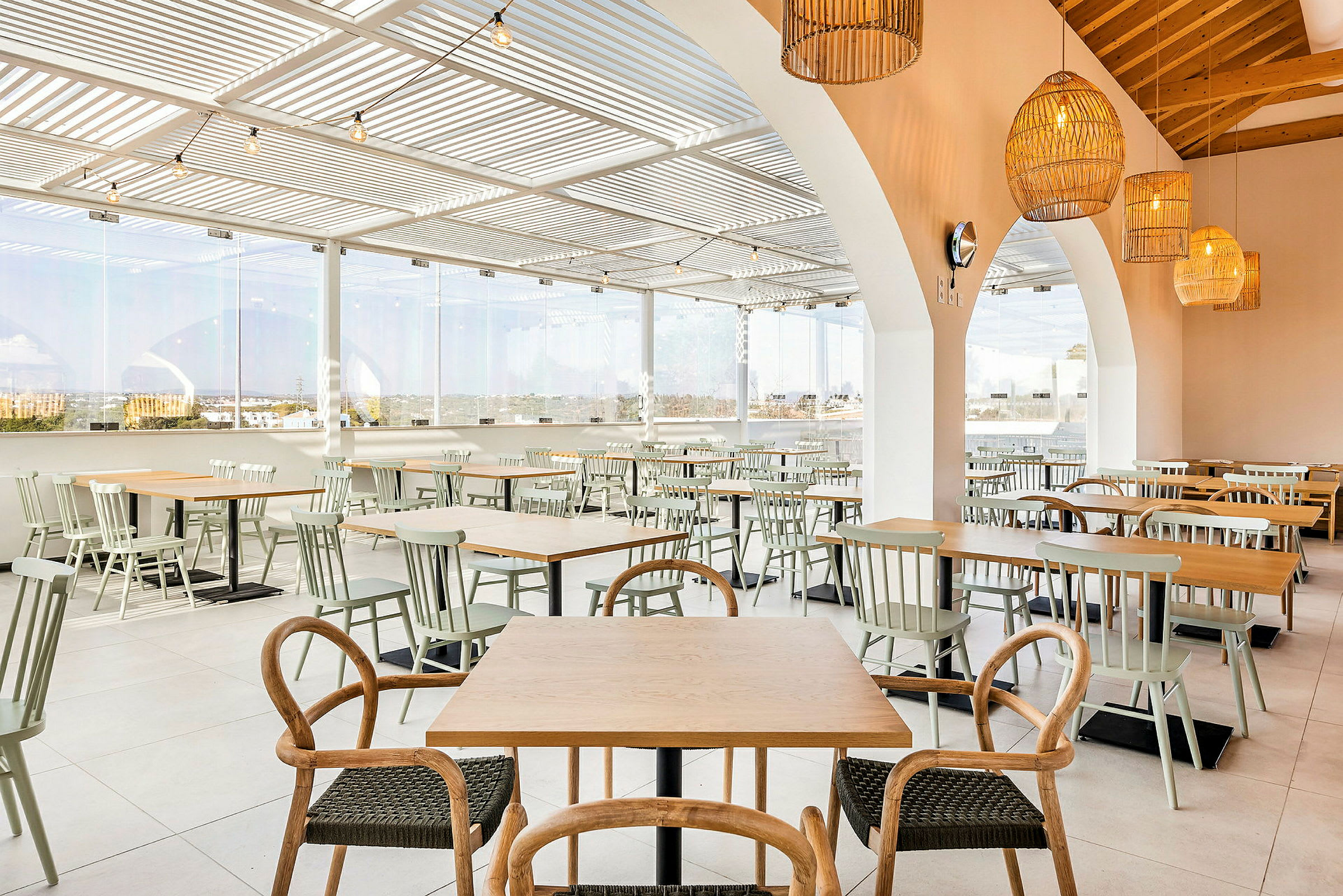 Bilde av en restaurant med bord og stoler i et åpent og lyst rom. (AI-generert tekst)