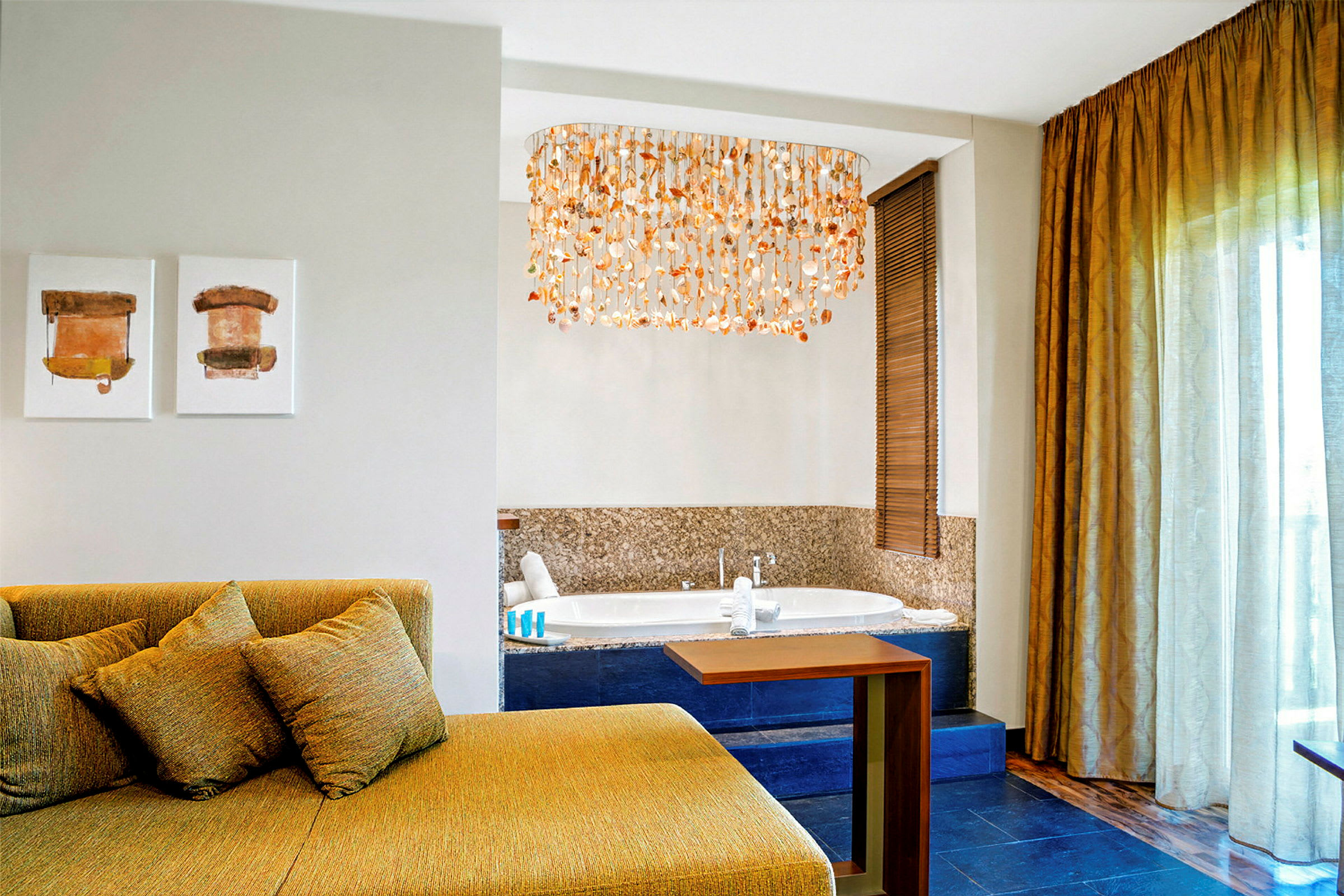 Interiør av et hotellrom med en sittegruppe, kunst på veggen, et boblebad og en dekorativ taklampe. (AI-generert tekst)