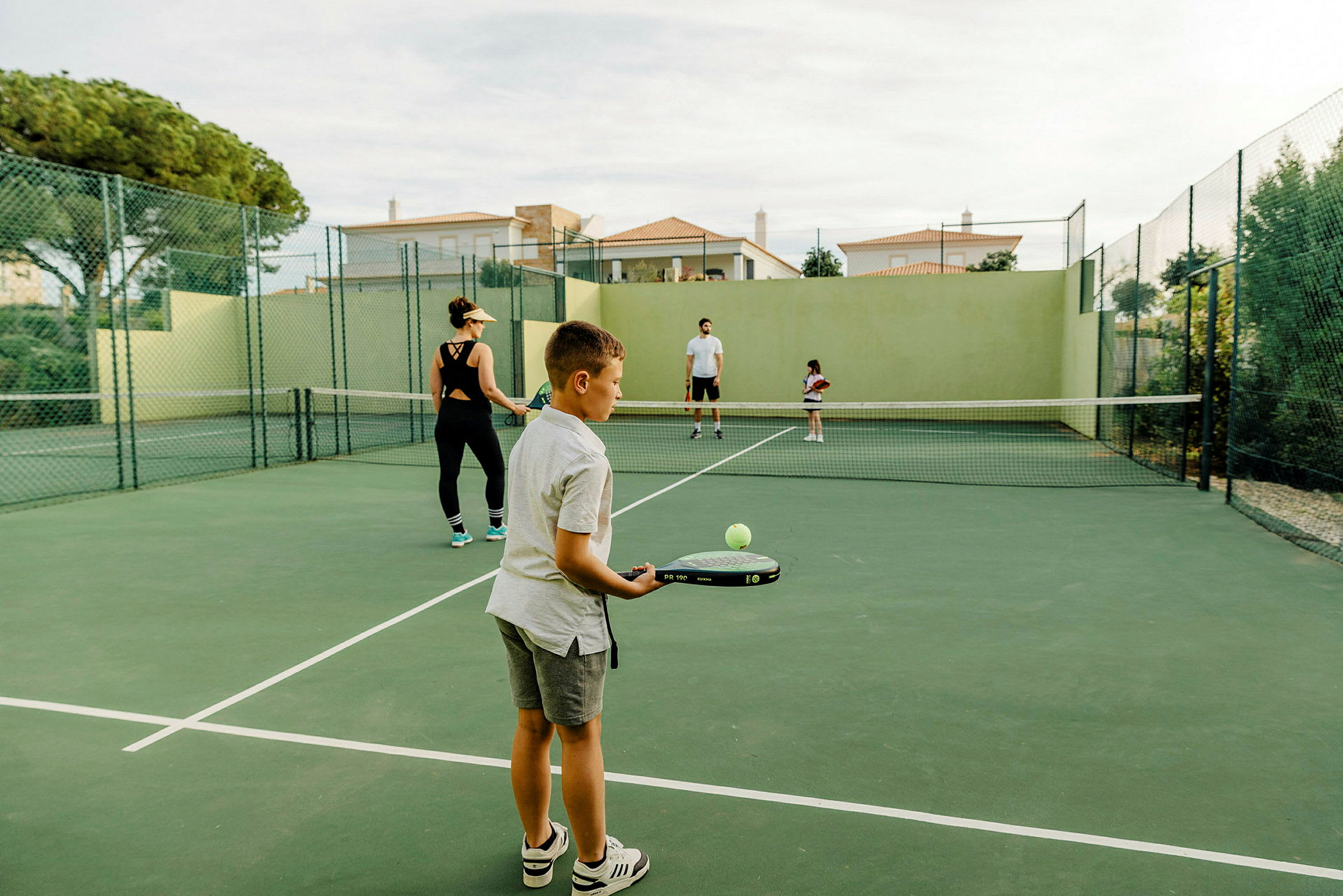 En tennisbane med personer som spiller tennis. (AI-generert tekst)