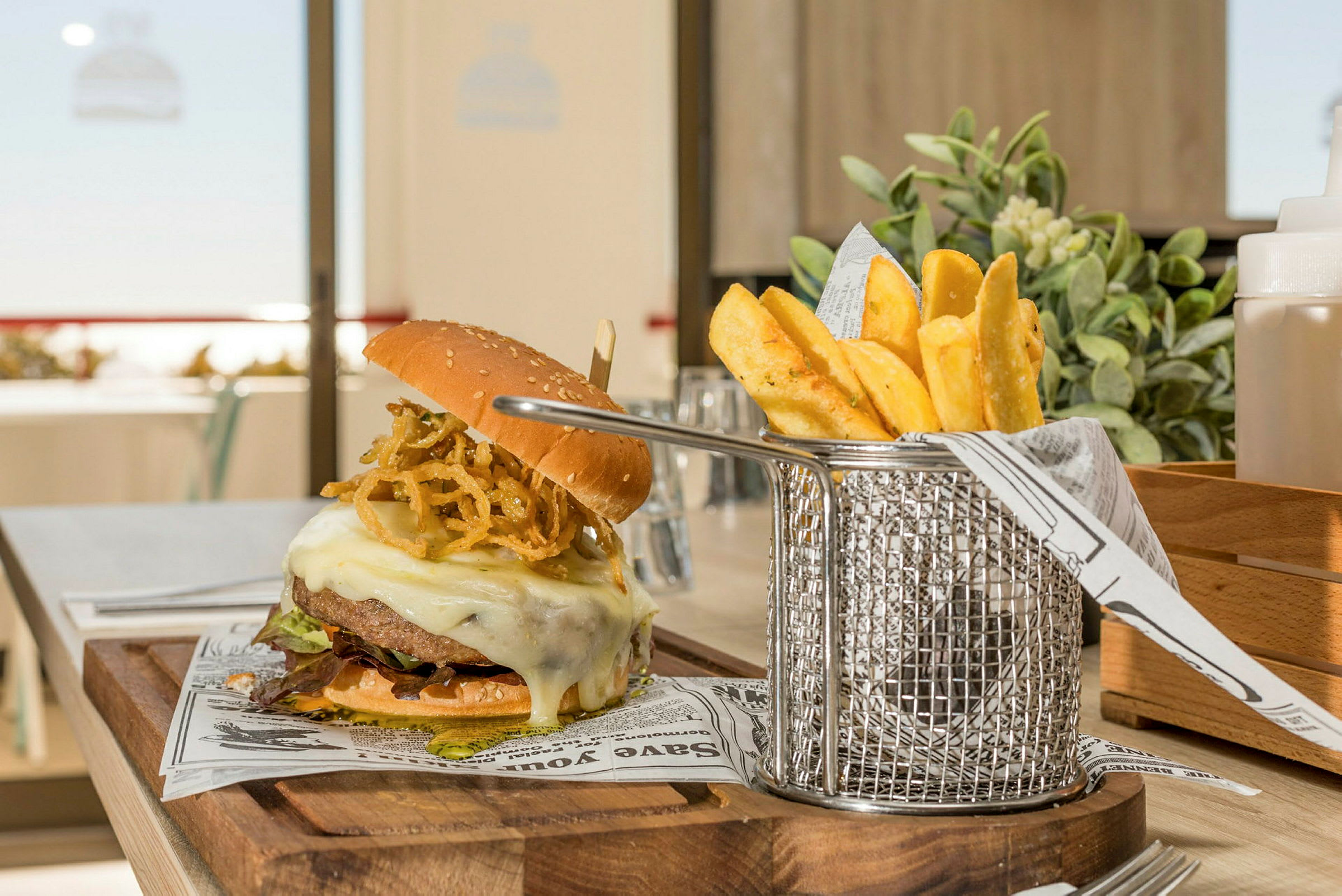 En hamburger med ost og pommes frites serveres. (AI-generert tekst)