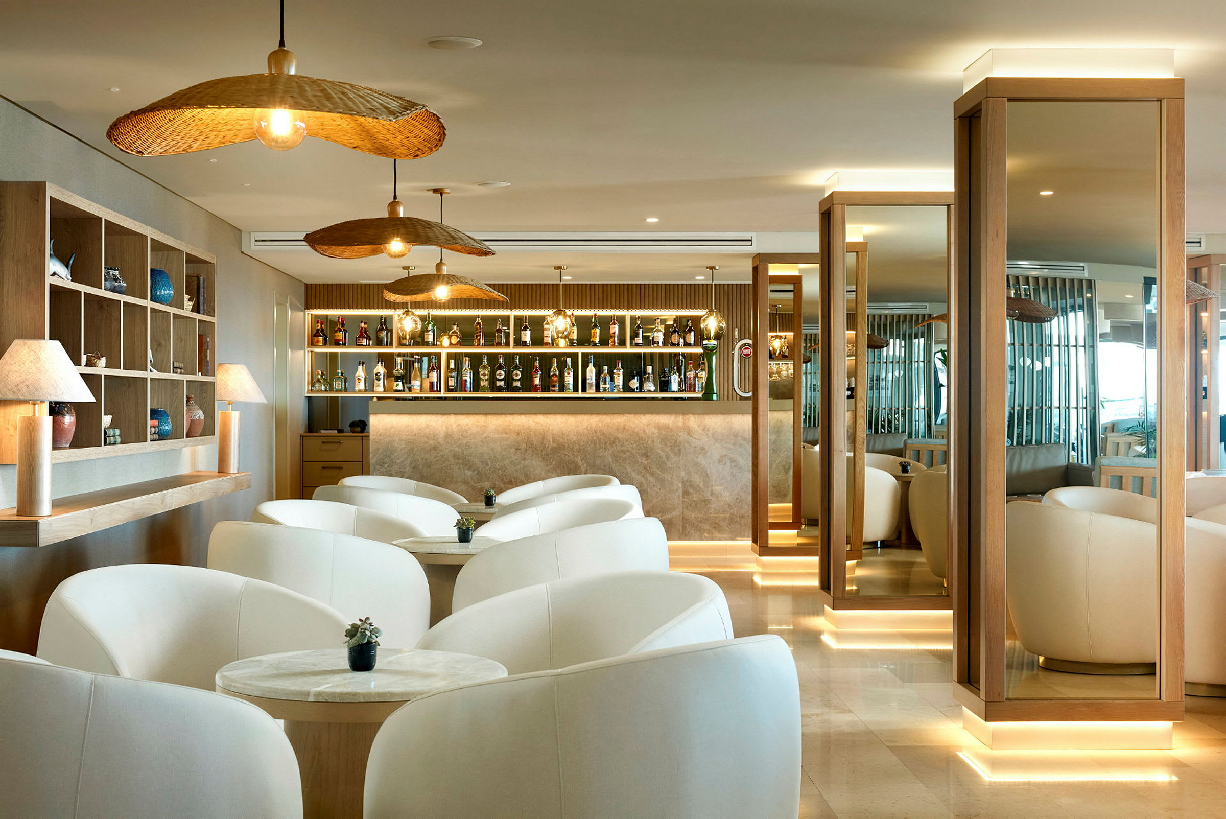 Bilde av en moderne lounge med hvite lenestoler, treinnslag og en opplyst bar. (AI-generert tekst)
