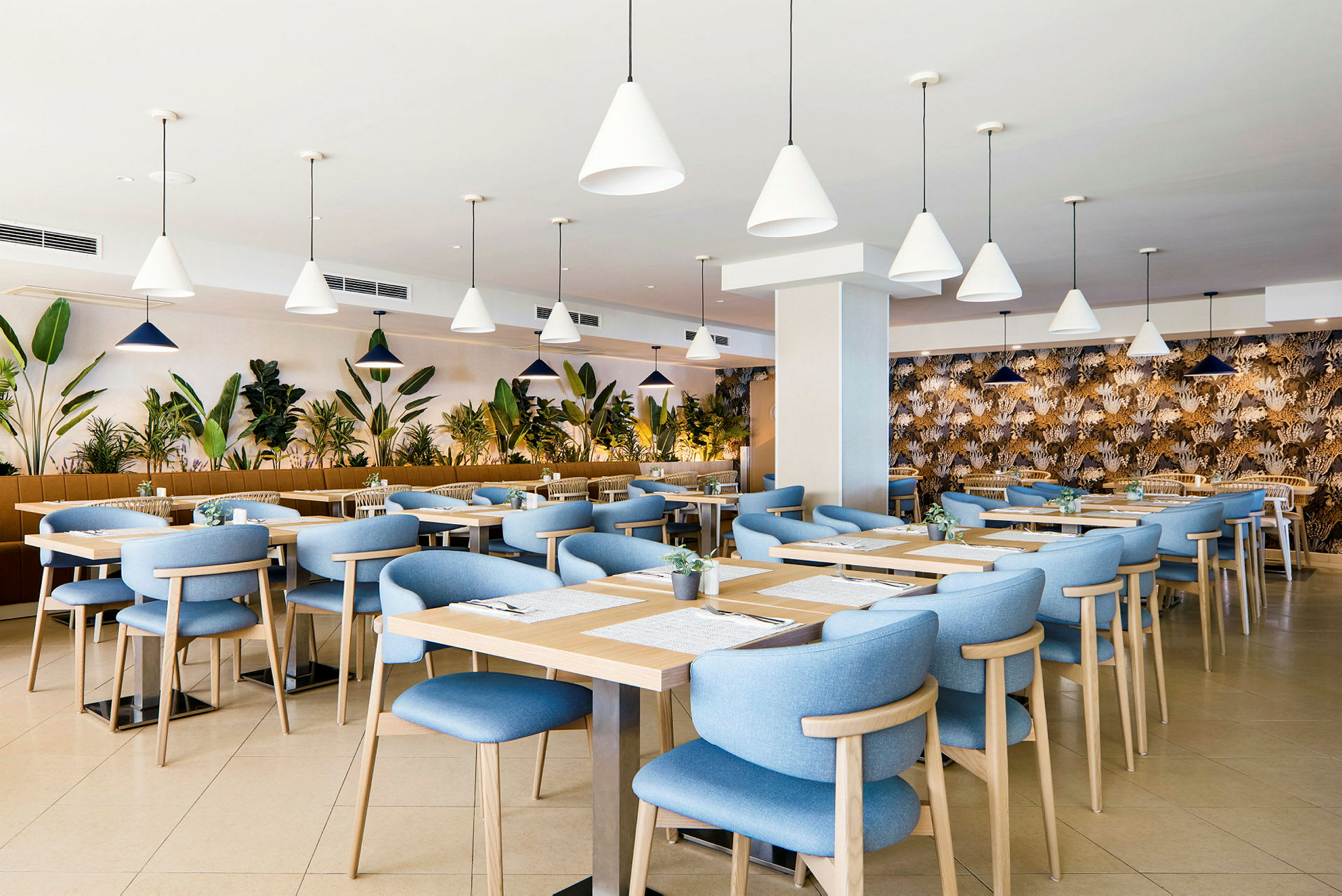 Restaurant med blå stoler og trebord, omgitt av planter. (AI-generert tekst)