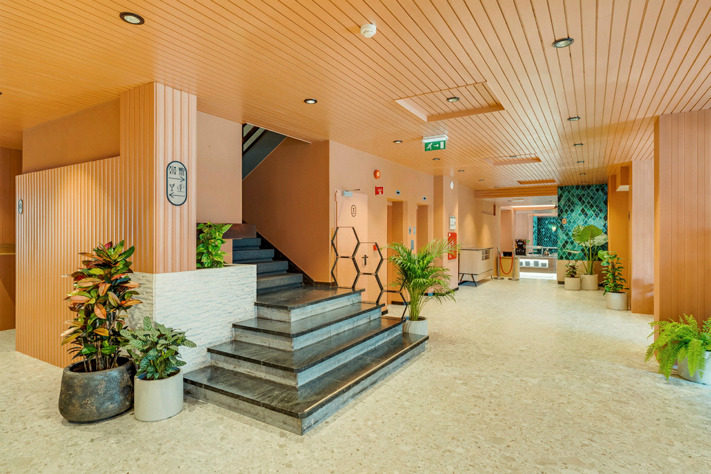 Hotellobby med trapp og dekorative planter. (AI-generert tekst)