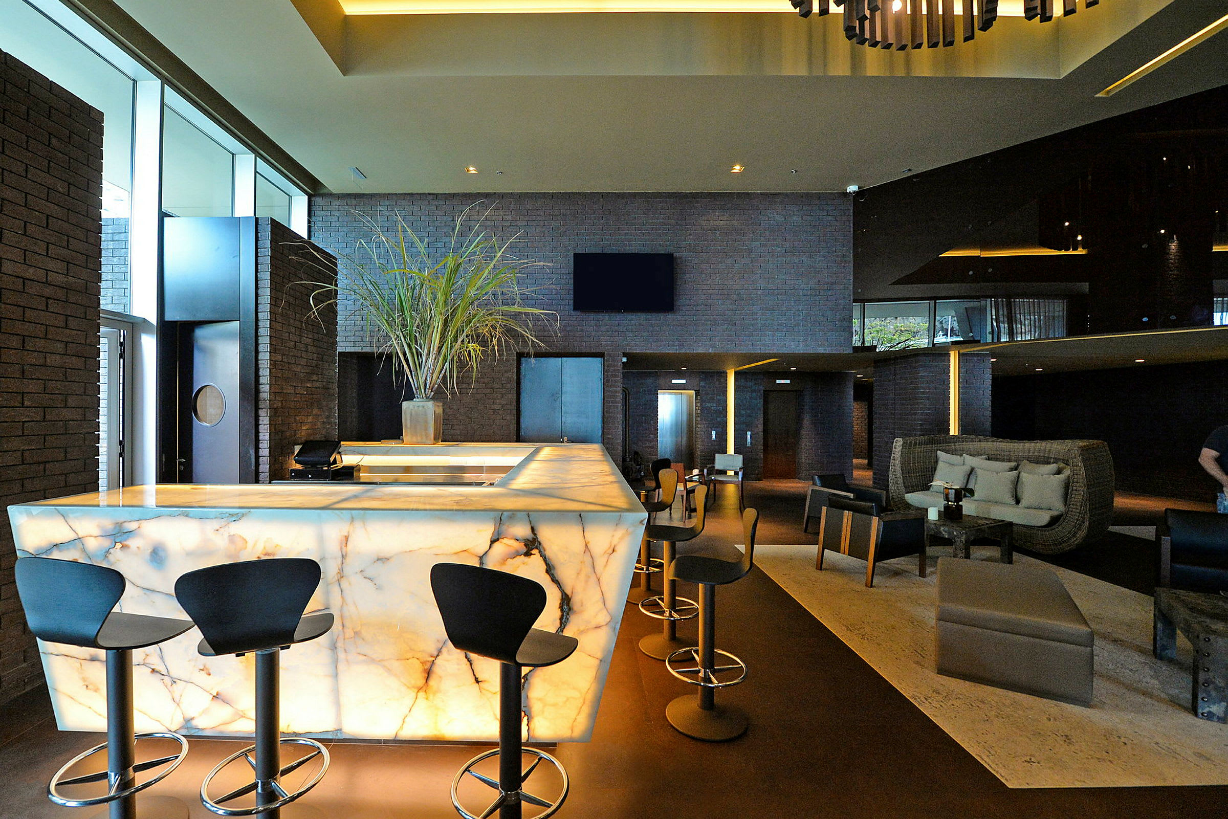 Bilde av en moderne hotellobby med en opplyst marmordisk og stilfull innredning. (AI-generert tekst)