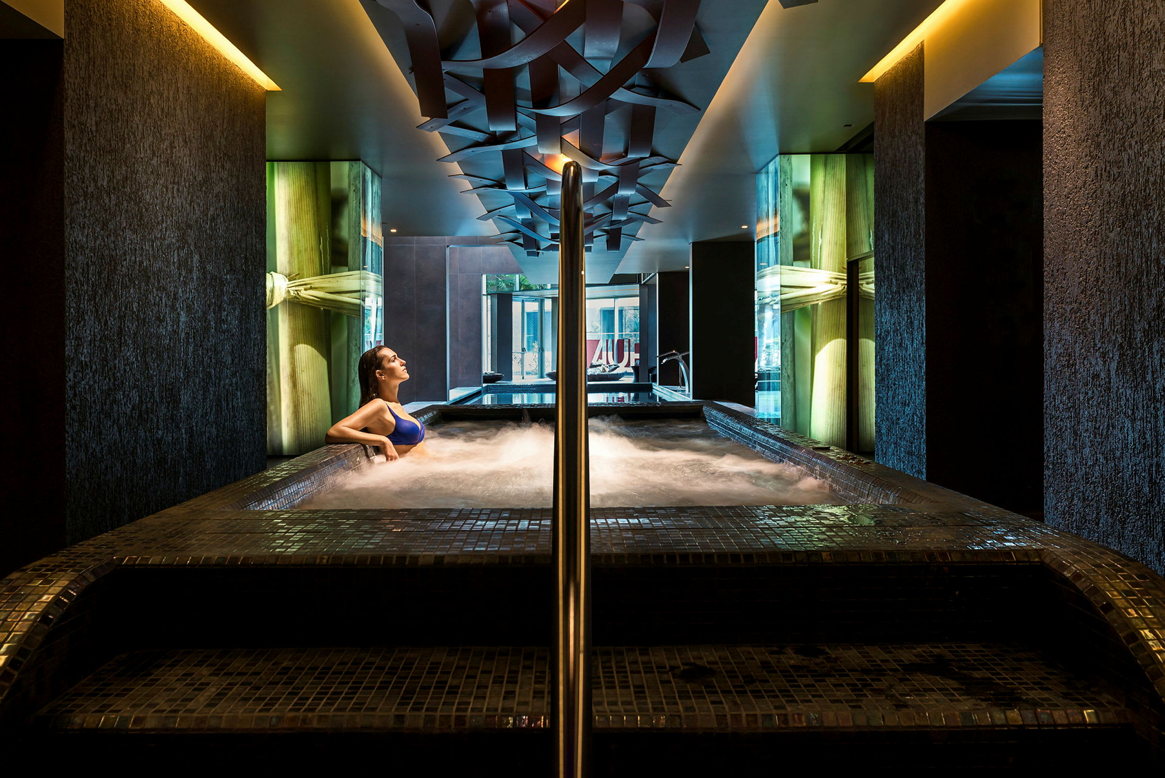 En person sitter i en boblebad i et moderne spa. (AI-generert tekst)