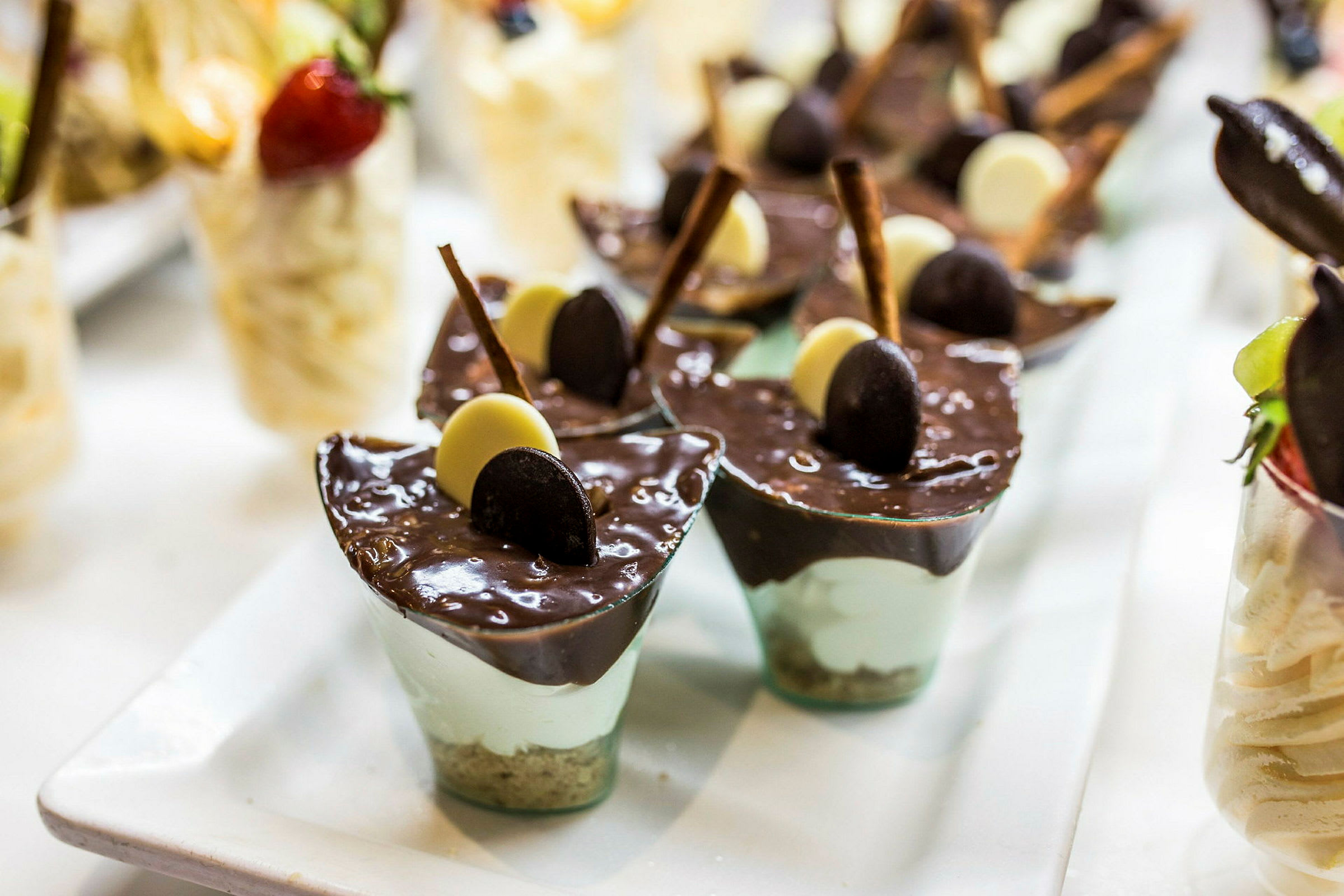 Små dessertglass med sjokolademousse og dekorasjoner. (AI-generert tekst)