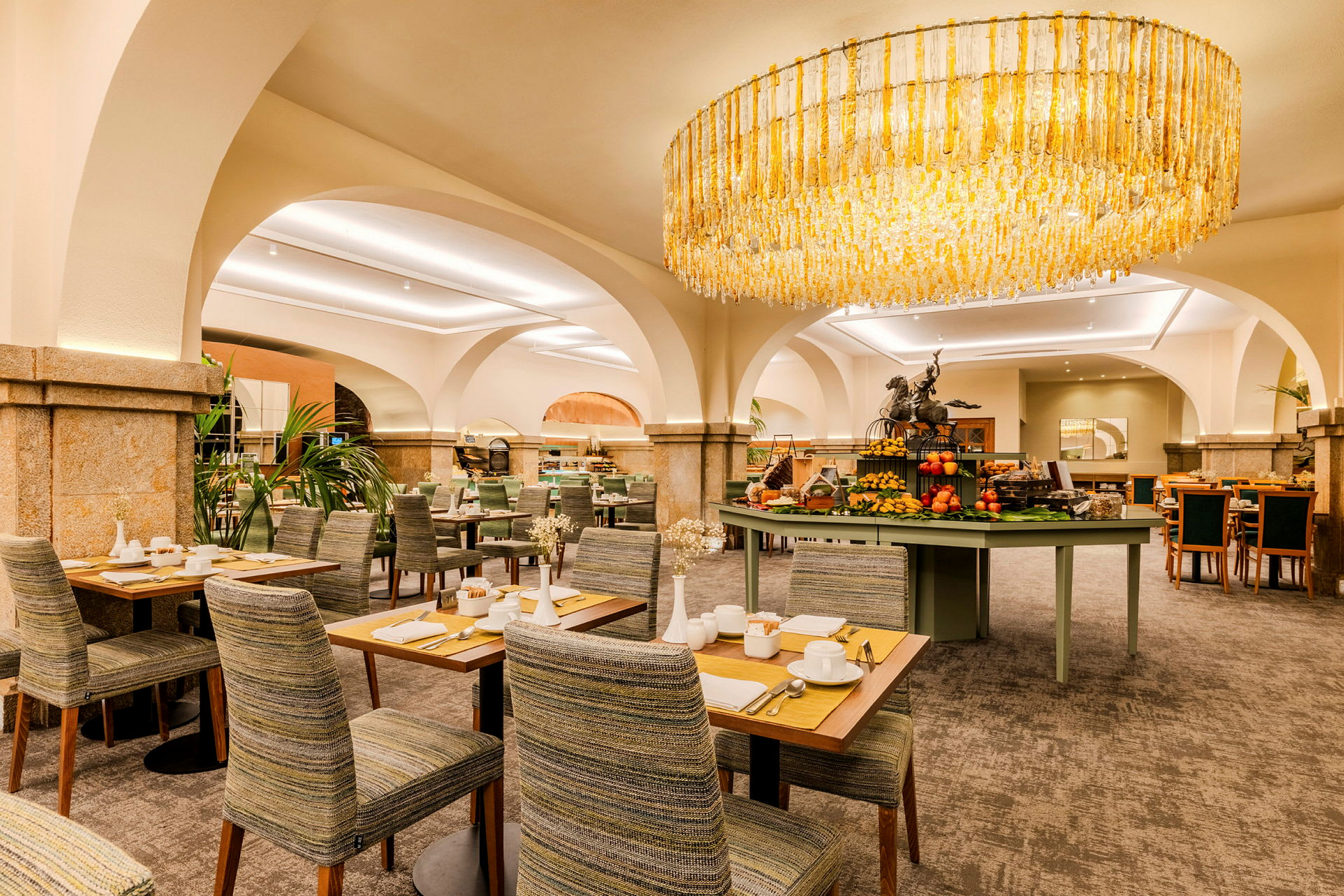 Interiør av en elegant restaurant med sitteplasser og en lysekrone. (AI-generert tekst)