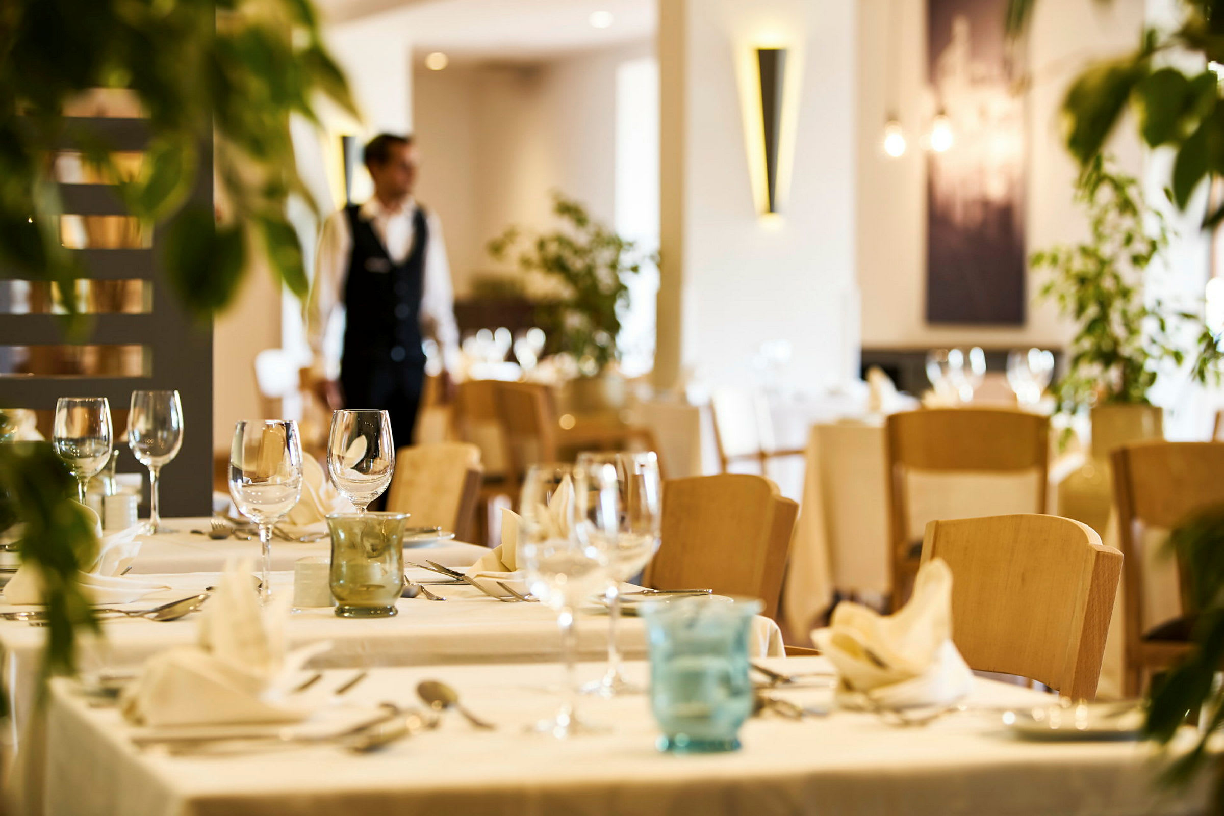Restaurantmiljø med dekkede bord og glass. (AI-generert tekst)