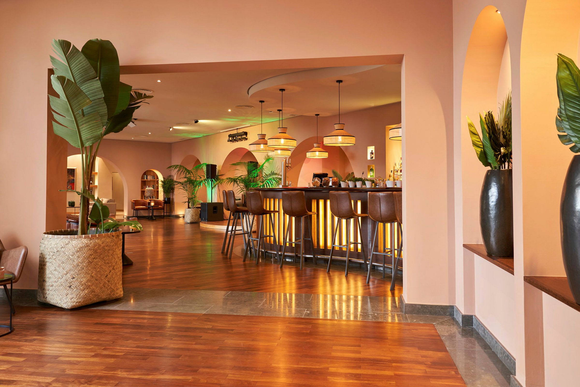 Interiør av en moderne restaurant med bar, planter og hengende lamper. (AI-generert tekst)