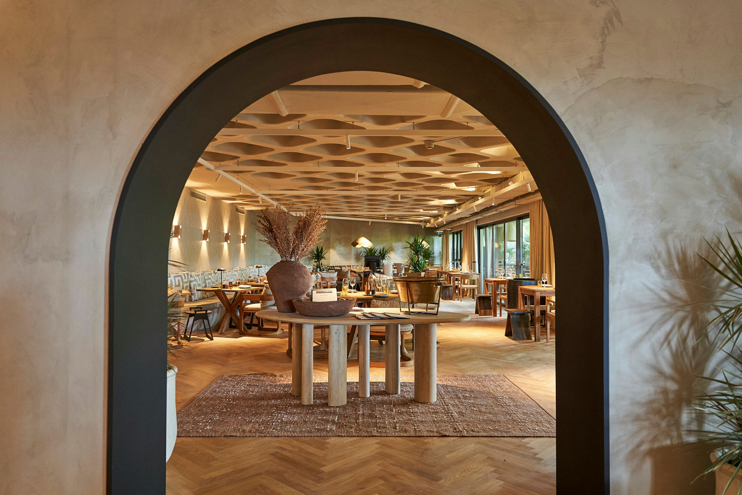 Arkitektur i en restaurant med en bue som åpning og tredetaljer i interiøret. (AI-generert tekst)