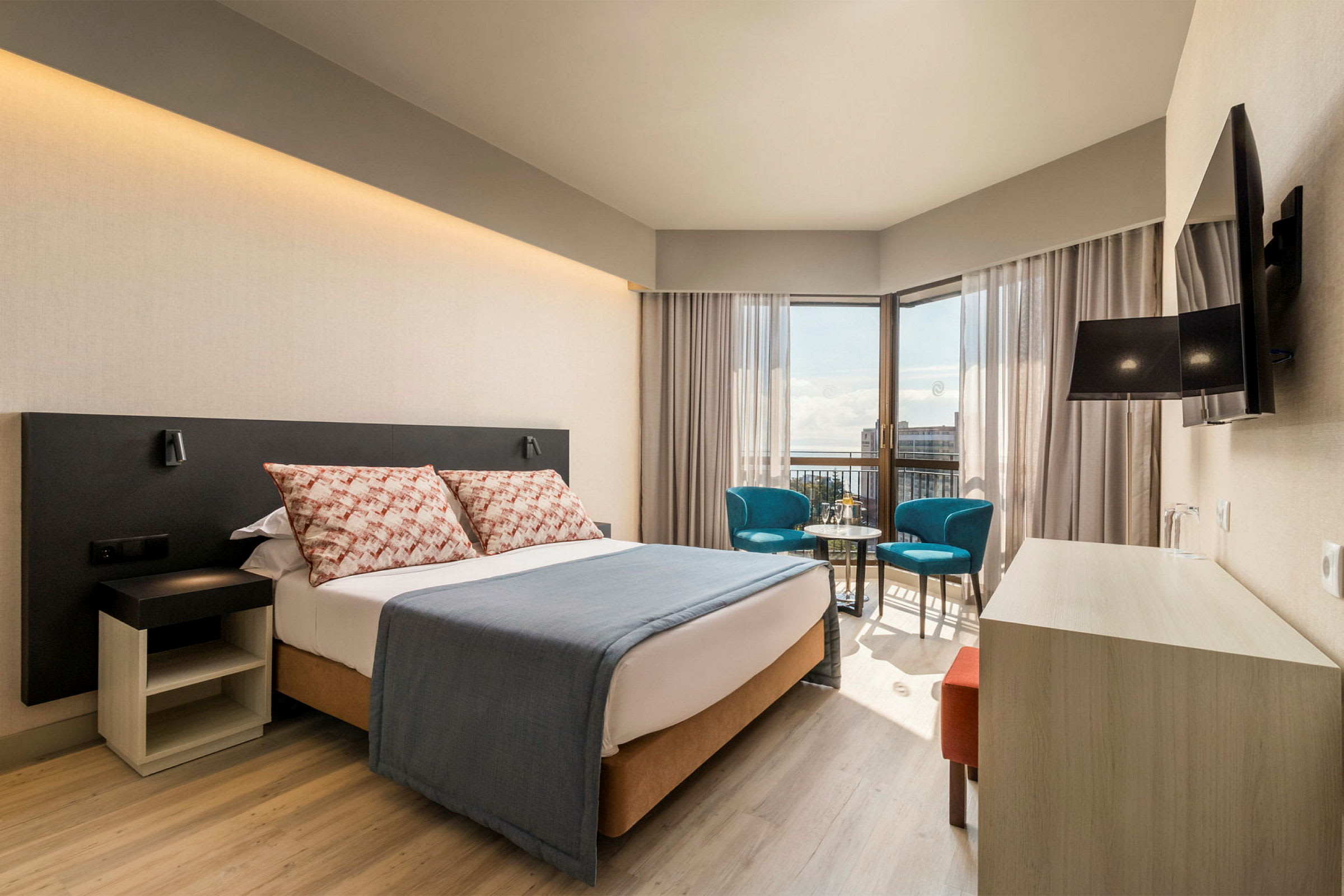 Moderne hotellrom med dobbeltseng, sittegruppe og utsikt. (AI-generert tekst)