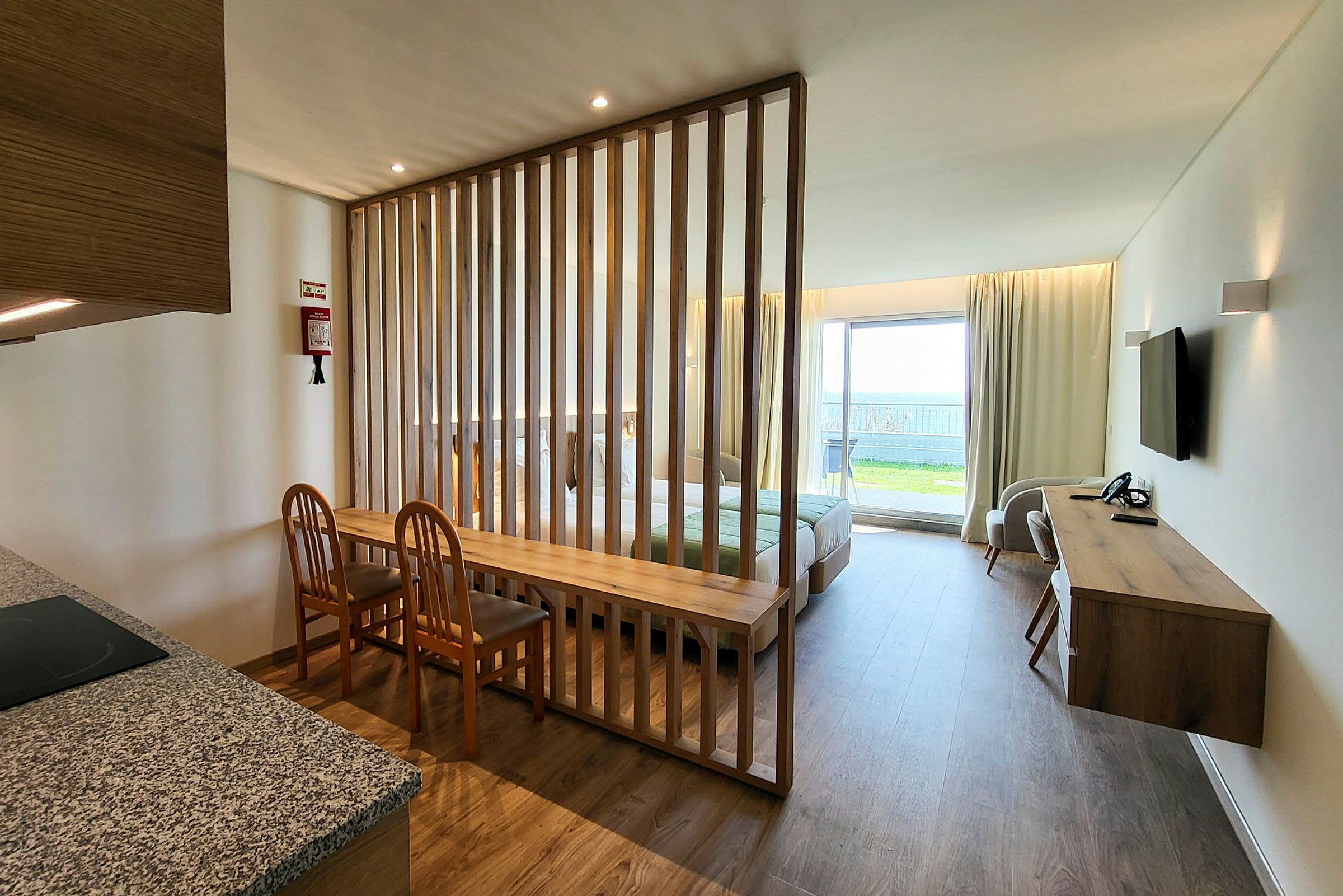 En godt opplyst hotellrominteriør med adskillelse av trelameller. (AI-generert tekst)