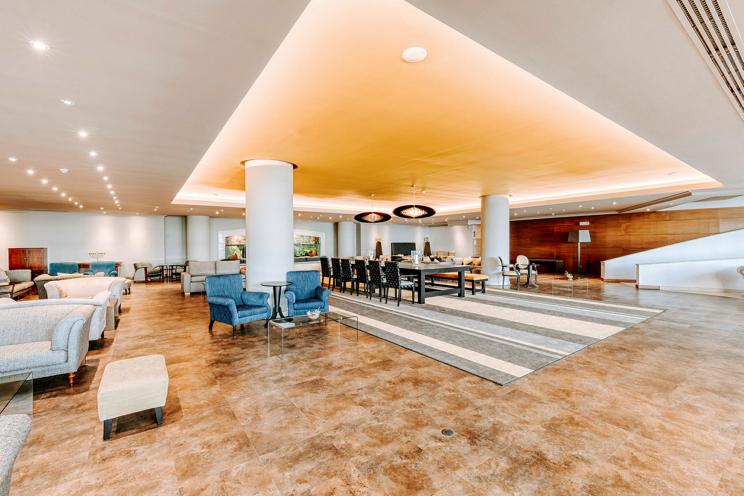 Bilde av en romslig og godt opplyst lounge med sitteplasser og bord. (AI-generert tekst)