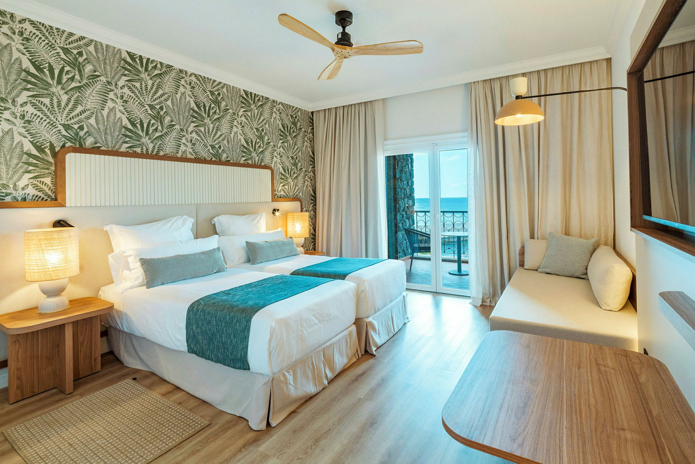 Hotellrom med to enkeltsenger og en balkong med havutsikt. (AI-generert tekst)