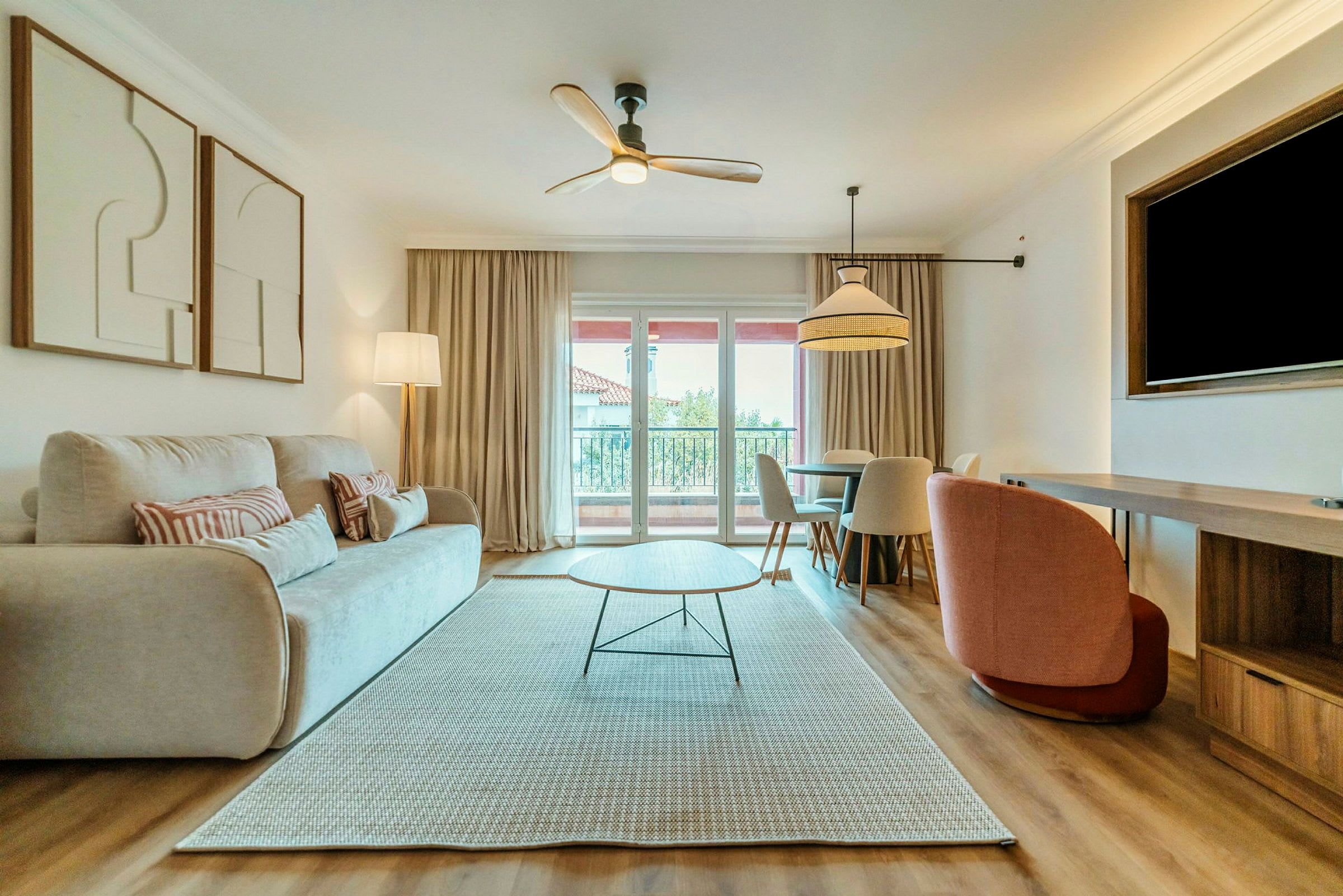 En stue med en lys sofa, et moderne sofabord og et spisebord med stoler. Et vindu med gardiner slipper inn dagslys. (AI-generert tekst)