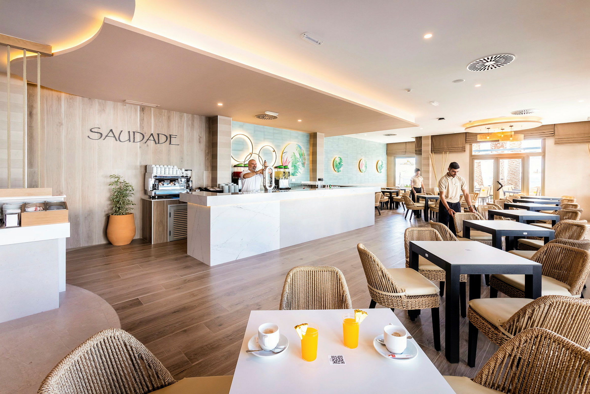 Interiør av en moderne restaurant med en kaffestasjon og bord med sitteplasser. (AI-generert tekst)