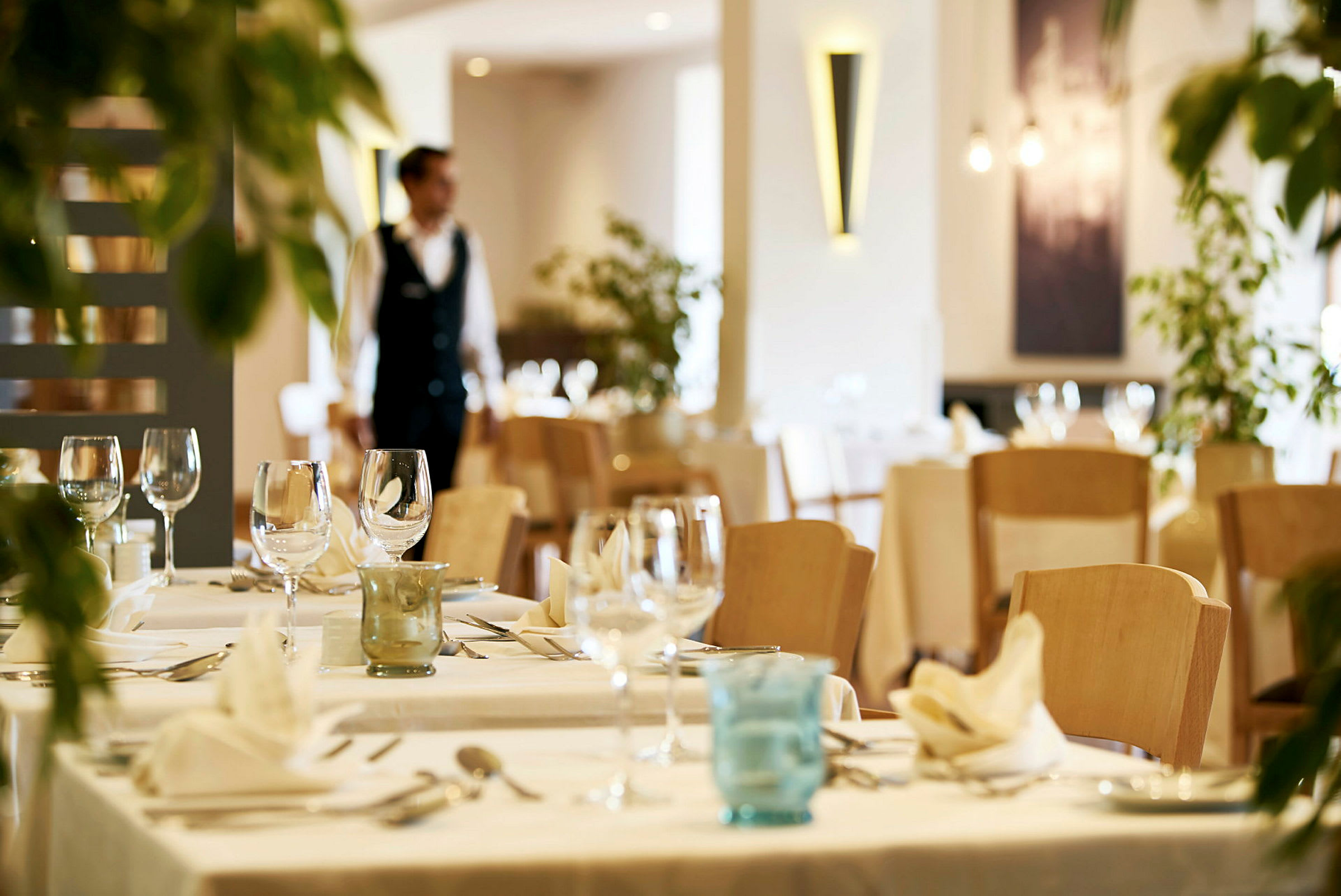 En restaurant med dekkede bord og glass. (AI-generert tekst)