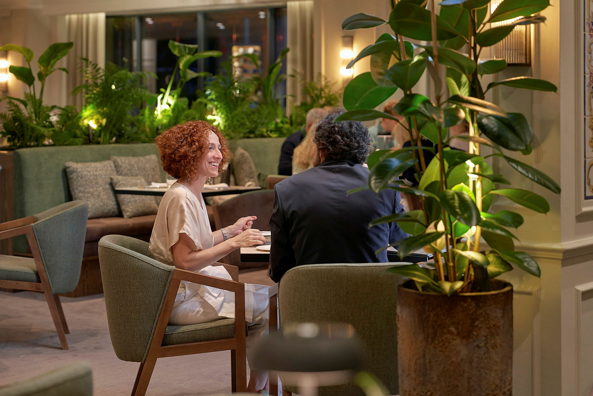 To personer sitter ved et bord i en stemningsfull restaurant. (AI-generert tekst)