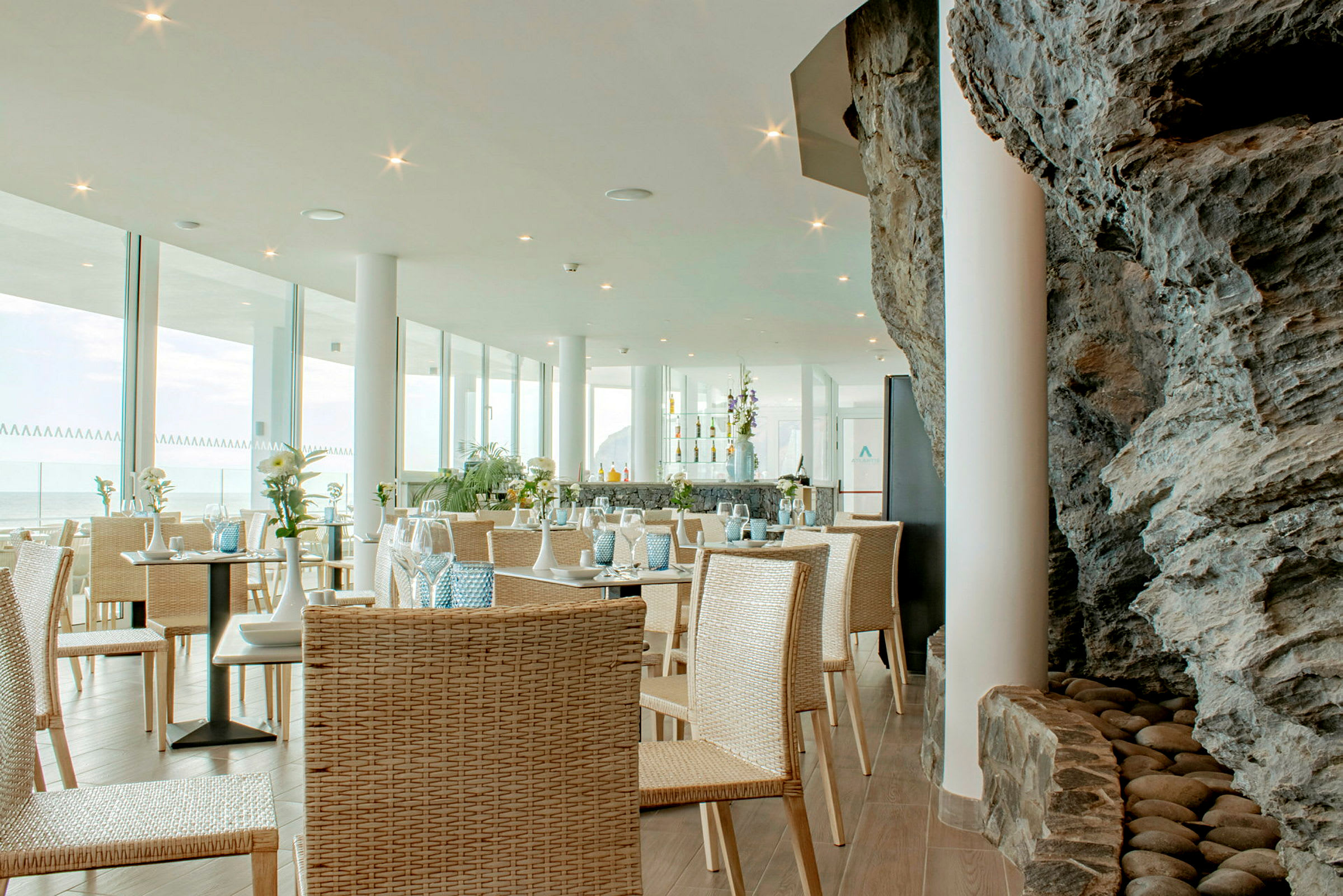 En restaurant med glassvegger og interiør av naturmaterialer. (AI-generert tekst)